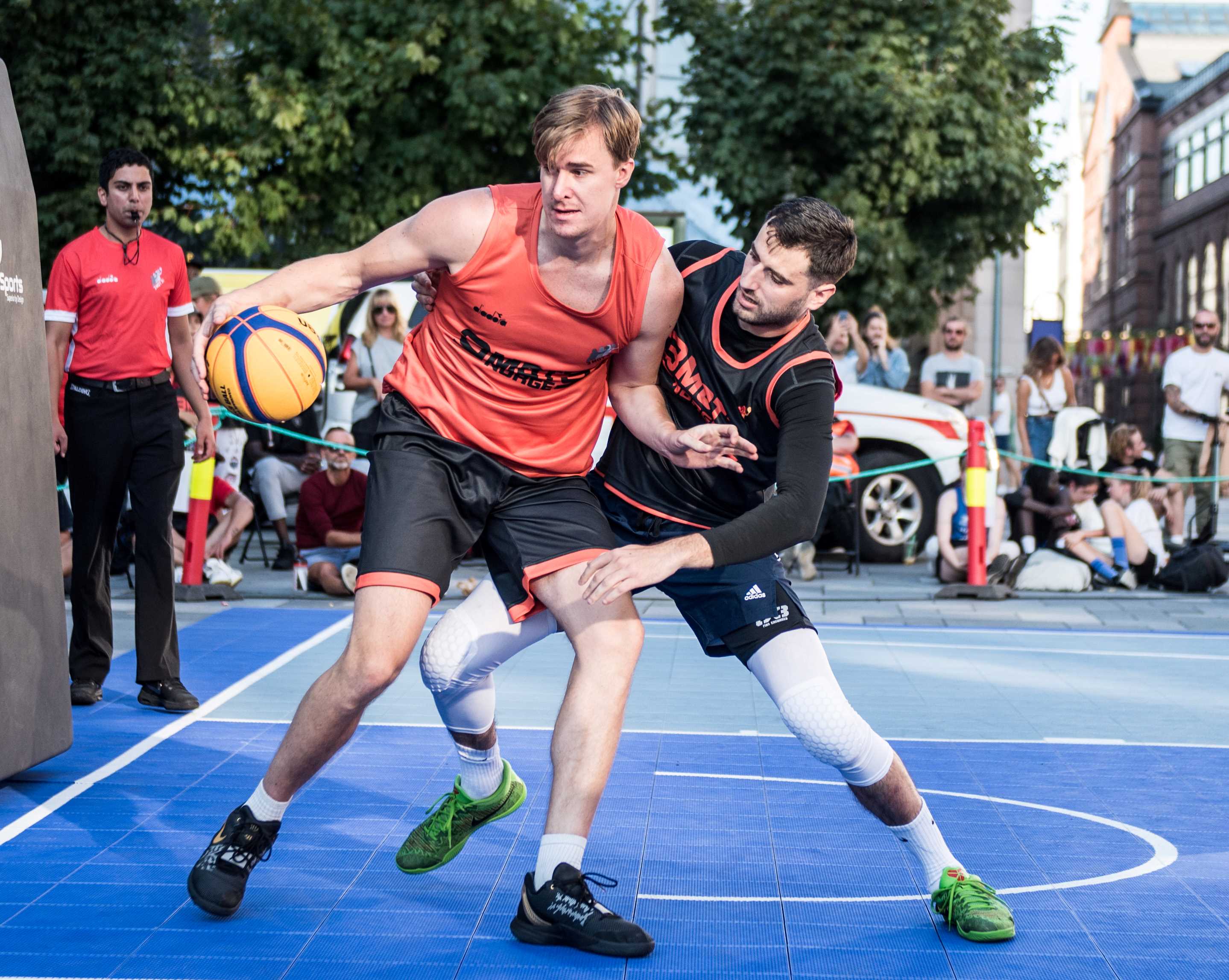 Sigurd Staver fra Tigers Nation får tøff oppdekking av Miners-guard Ognjen Nisavic i 3x3-finalen på Bryggetorget i Oslo. Bak ser vi dommer Yousuf Sultany.
FOTO: ERIK BERGLUND    