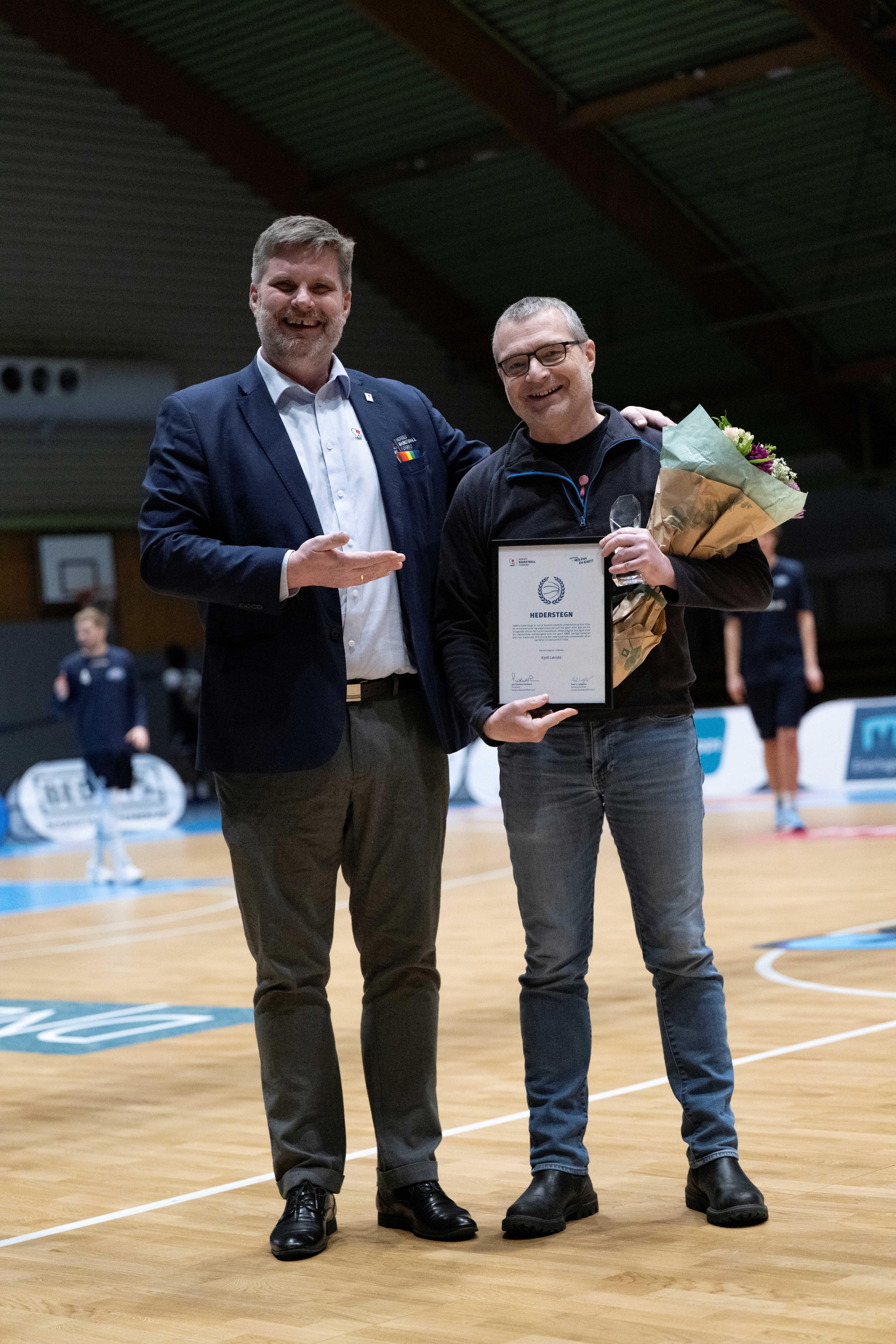 Kjell Løvold med blomster og Hederstegnet han nettopp har mottatt fra basketpresident Jan Hendrik Parmann.
FOTO: GRY BERNTZEN 
