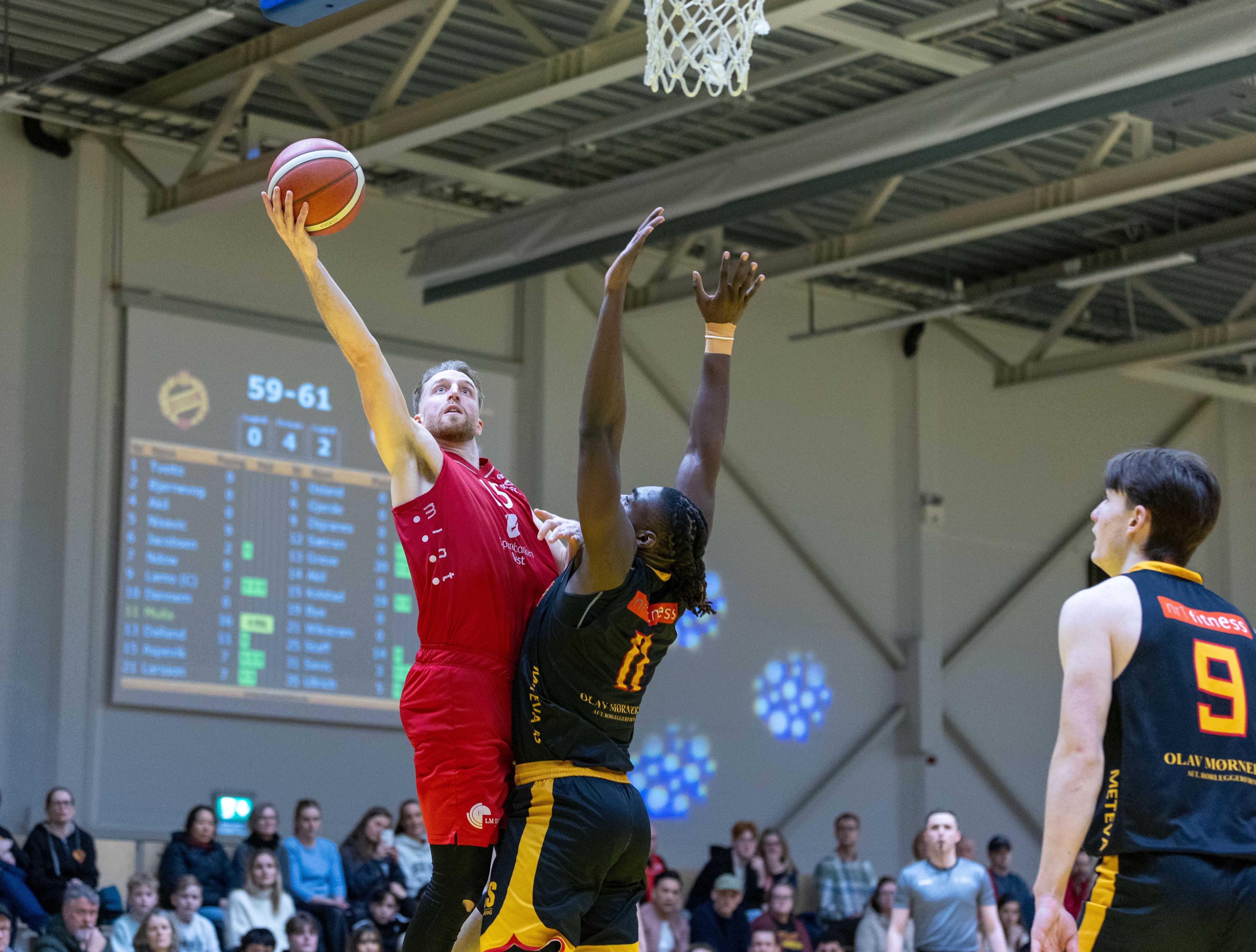 Mikkel Kolstad har kommet seg inn under Frøyas kurv og legger to av sine 27 poeng, presset av hjemmelagets ledende spiller JD Muila. Til høyre i bildet er Jørgen Lamo, som la Frøyas siste trepoenger og scoring til 75-76 et drøyt minutt før slutt.
FOTO: BRAGE TITLESTAD 