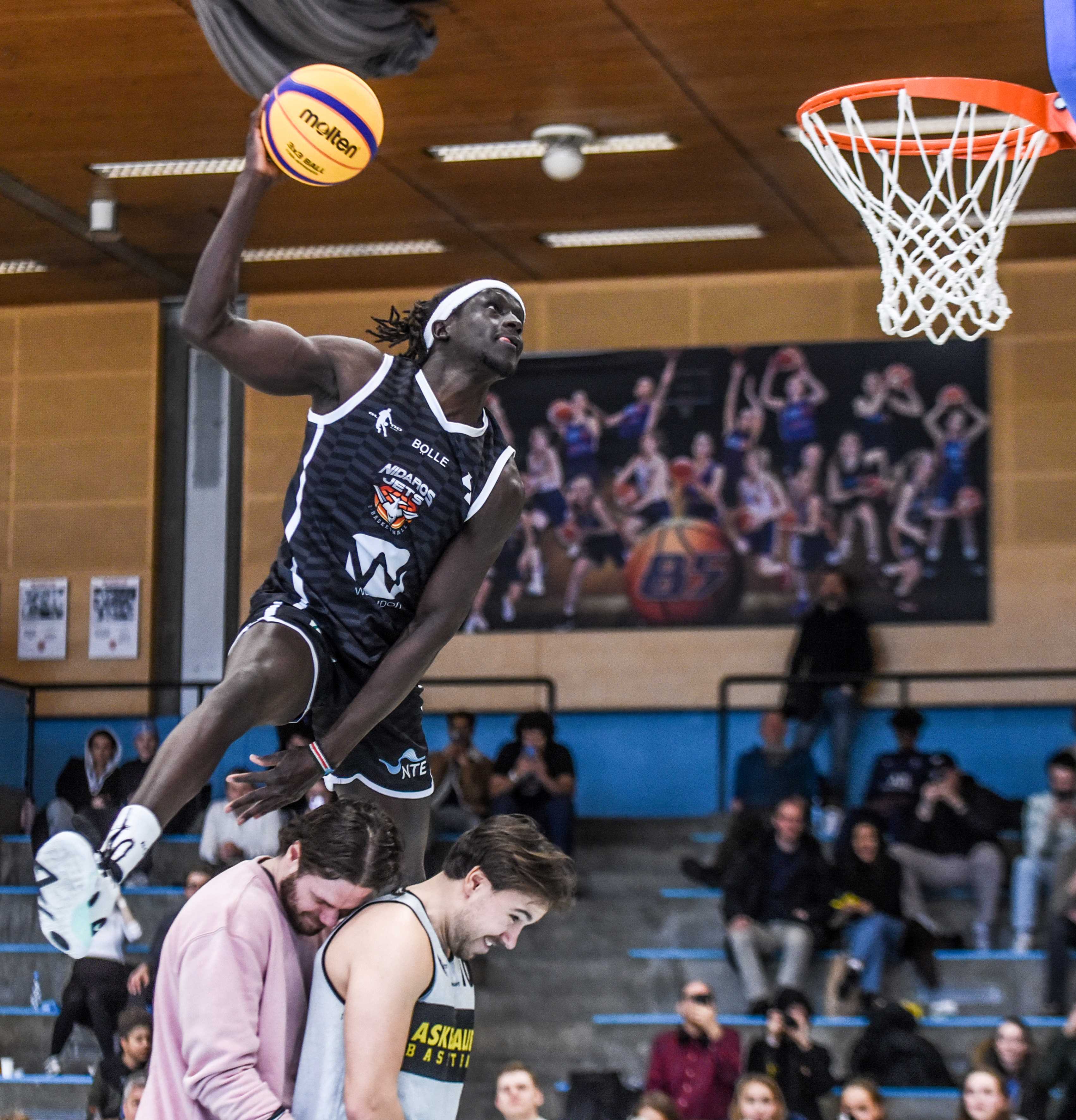 Ringo Dau spenster over Asker-spillerne Benjamin Alknes Cox og Ludvig Bergh og serverer vinnerdunken i konkurransen i Nadderudhallen. Nidaros-forwarden lå bak Åke Swahn i poeng etter to dunker, men avgjorde i finaleomgangen.
FOTO: ERIK B. BERGLUND 