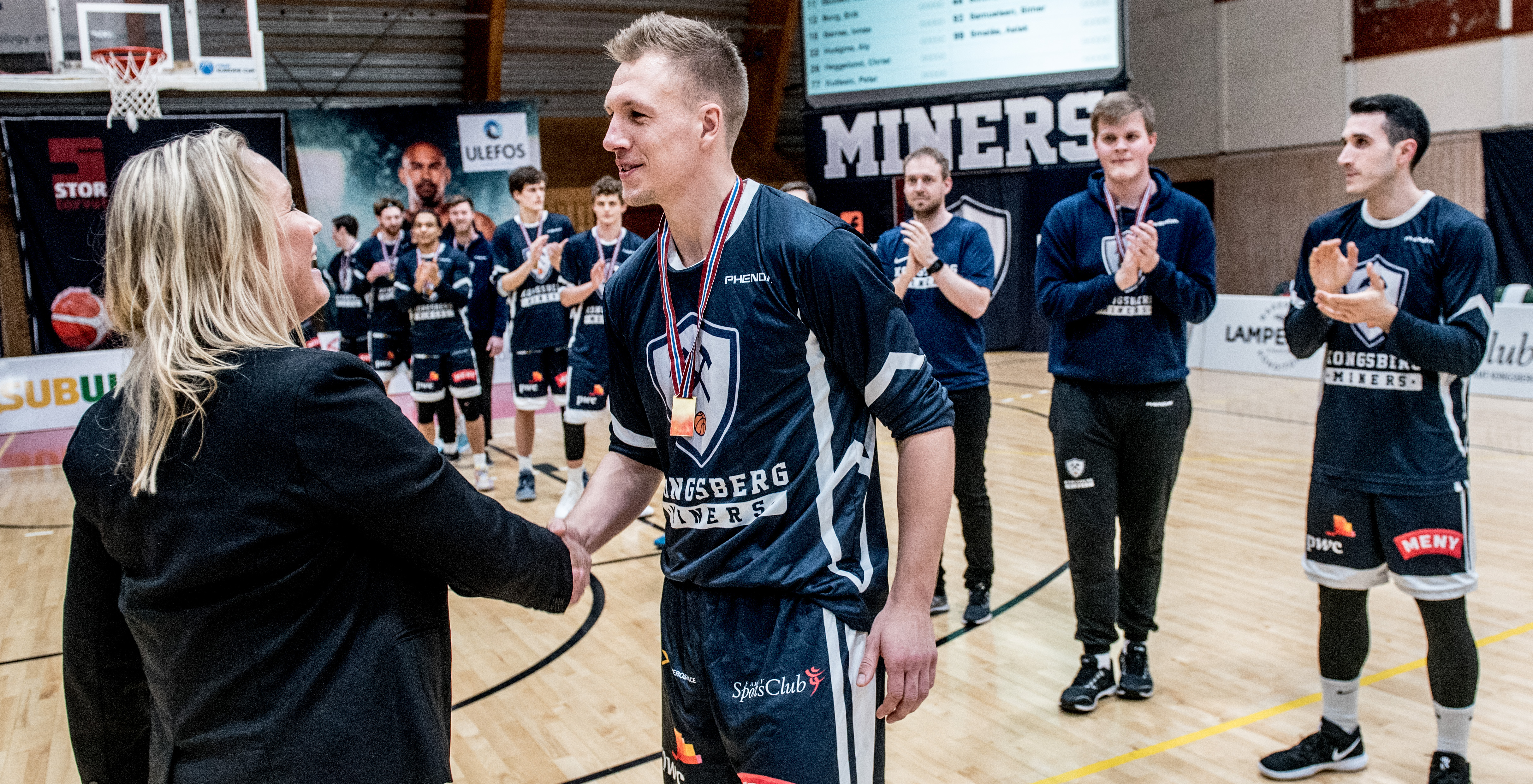 Nikolas Skouen får gullmedalje for seriemesterskapet fra NBBFs generalsekretær Silje Særheim. Nærmest og fra høyre ser vi lagkaptein Juan Ferrales, Kristian Groth Eggar og fysioterapeut Frederic Solberg. FOTO: ERIK BERGLUND