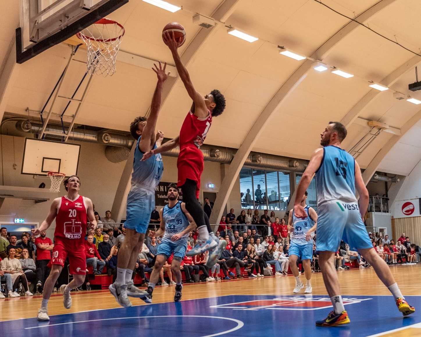 Lars Fredrik Espe flyr høyt og legger to av sine 10 poeng over Sjur Dyb Berg. Gimles pointguard måtte ut med overtråkk i sluttminuttene, men skal være klar til finale nummer to i Nadderudhallen neste tirsdag. De øvrige spillerne i bildet er fra venstre Eivind Lamo, Shane Temara, Benjamin Alknes Cox (delvis skjult) og Philipp Schwethelm.
FOTO: ASTRID HAGLAND GJERDE 