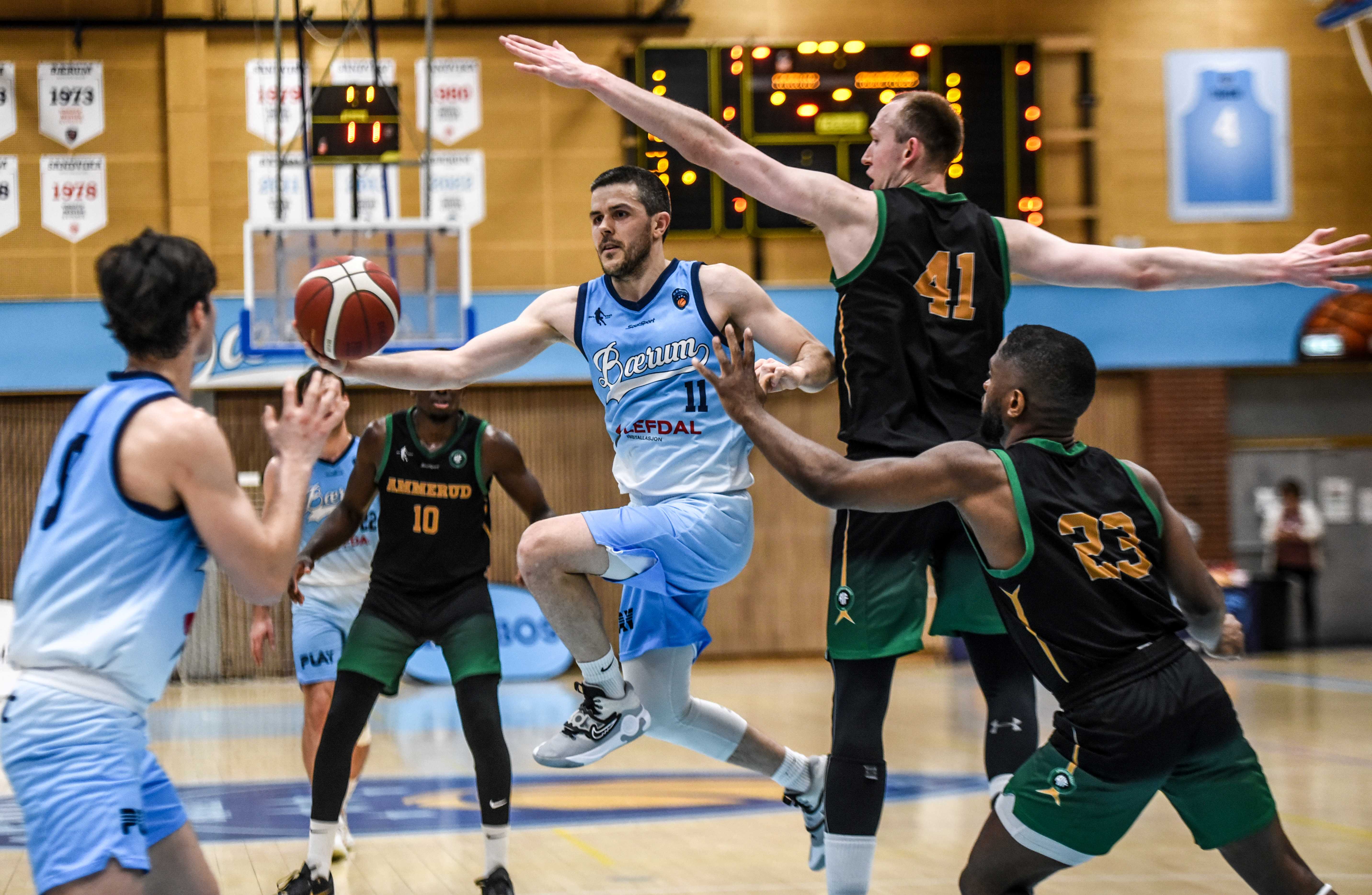  Stian Mjøs scoret 24 poeng og hadde 9 assists og 7 returer da Bærum slo Ammerud 95-86. Her driver hjemmelagets kaptein inn forbi Henrik Male Davidsen (nr 41) og Ilarion Bonhomme og legger en pasning inn til Scott Priestley. 
FOTO: ERIK B. BERGLUND 
