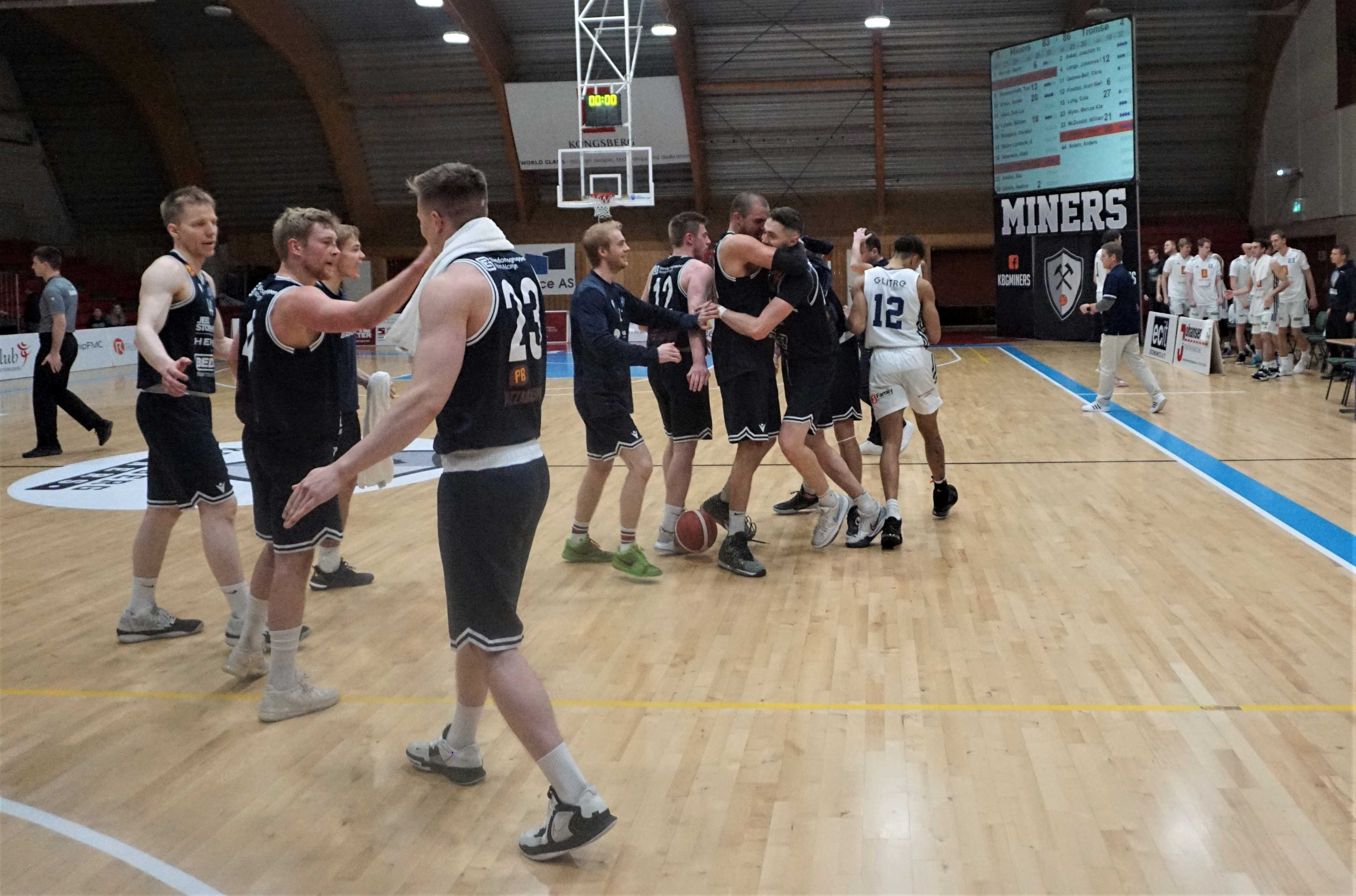 Tromsø Storms spillere jubler etter å ha påført Kongsberg Miners sesongens første tap. Nummer 23 er Marcus Wynn, videre mot venstre og rundt ser vi Johannes Rydningen Lange, Anders Solem, Joachim Vogt Aabel, Christopher Dobrée-Bell, Aron Nielsen Finstad og Petar Radojicic som omfavner matchvinner Cole Long, mens William McDonald er skjult bak Long. Samtidig spaserer en skuffet William Lybæk (nr 12) ut og mot Kongsberg Miners-benken.
FOTO: ARILD SANDVEN 