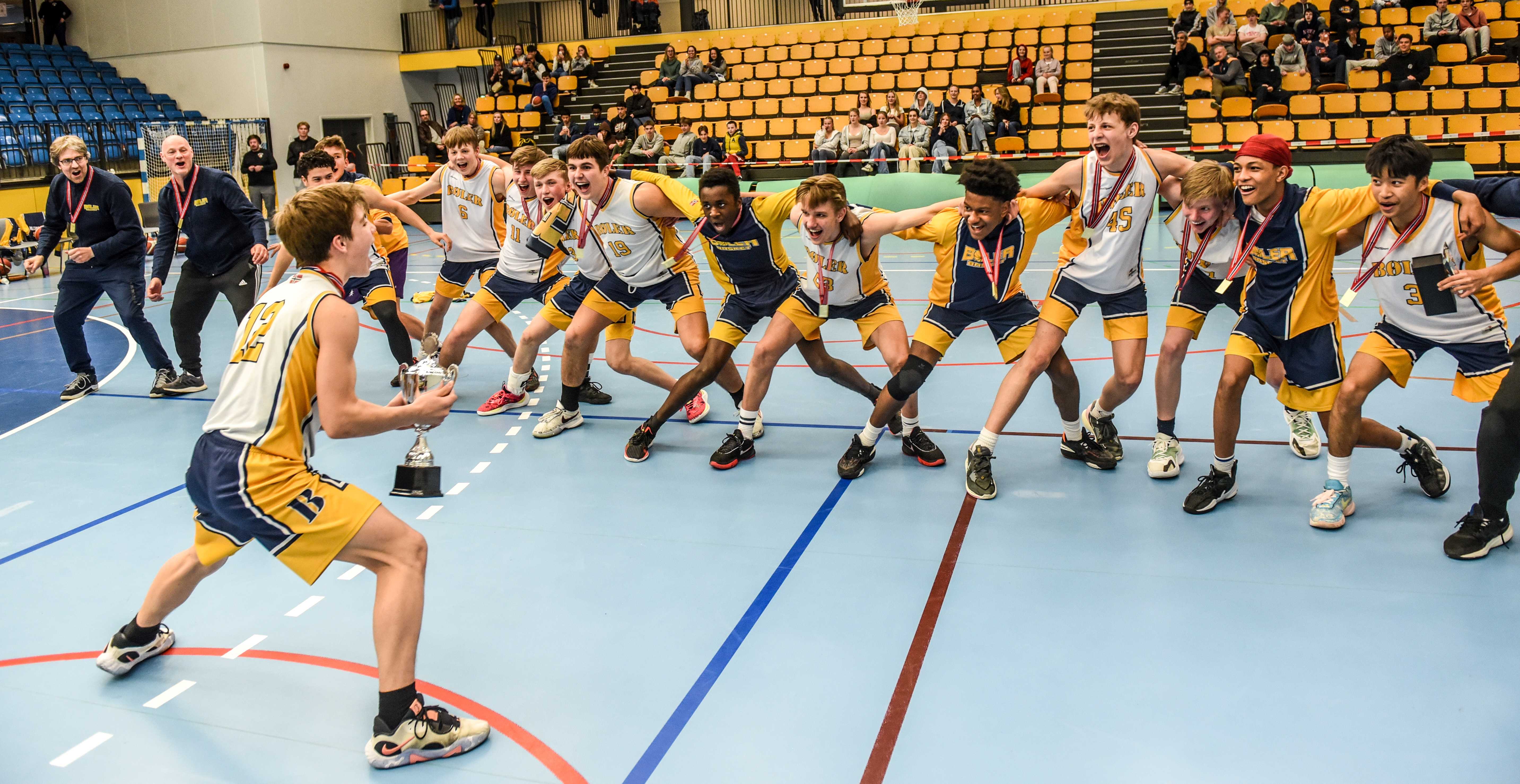 Bøler-kaptein Matei Argatu har nettopp mottatt NM-pokalen og hele laget feirer. Fra venstre ser vi assistenttrenerne Øystein Skår og Bjørnar Holsæter og deretter Ruben Driesprong Langerød (bak), Luis Gonzalez Graterol, Martin Døvle Mogeland, Felix Siljan-Kermit, Marius Westberg Carlsen, Jan Prus, Daniel Exauce Omedikonga, Viktor Brovold-Kühn, Darian Lugo-Mosquea, Morten Holsæter, Fredrik Skår, Chris Jayden Santamaria og Matthew Garcia, mens head coach Alexander Karlstad har danset seg litt ut av bildet!
FOTO: ERIK BERGLUND 
