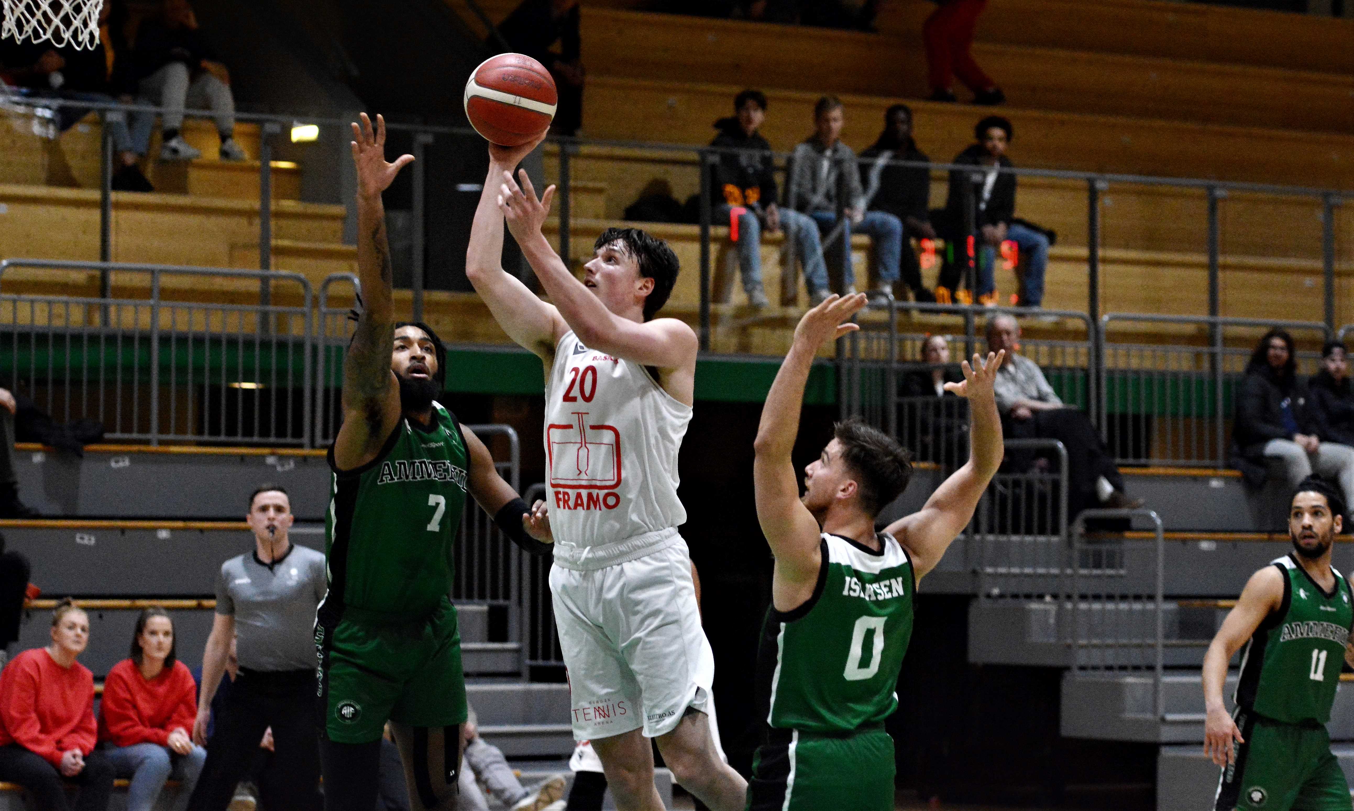 Eivind Lamo trosset hoftesmertene og var klar igjen til kamp mot Ammerud tirsdag etter å ha stått over søndag. 25-åringen ble viktig for Gimle, var toppscorer med 32 poeng og sentral både i forsvar og angrep da Ammerud ble slått 106-91. Her skyter han over Jordan Session. Til høyre i bildet er Andreas Isaksen og Erik Silva, bak til venstre ser vi dommer Alexander Ochoa Svendberg.
FOTO: MARIANNE MAJA STENERUD 