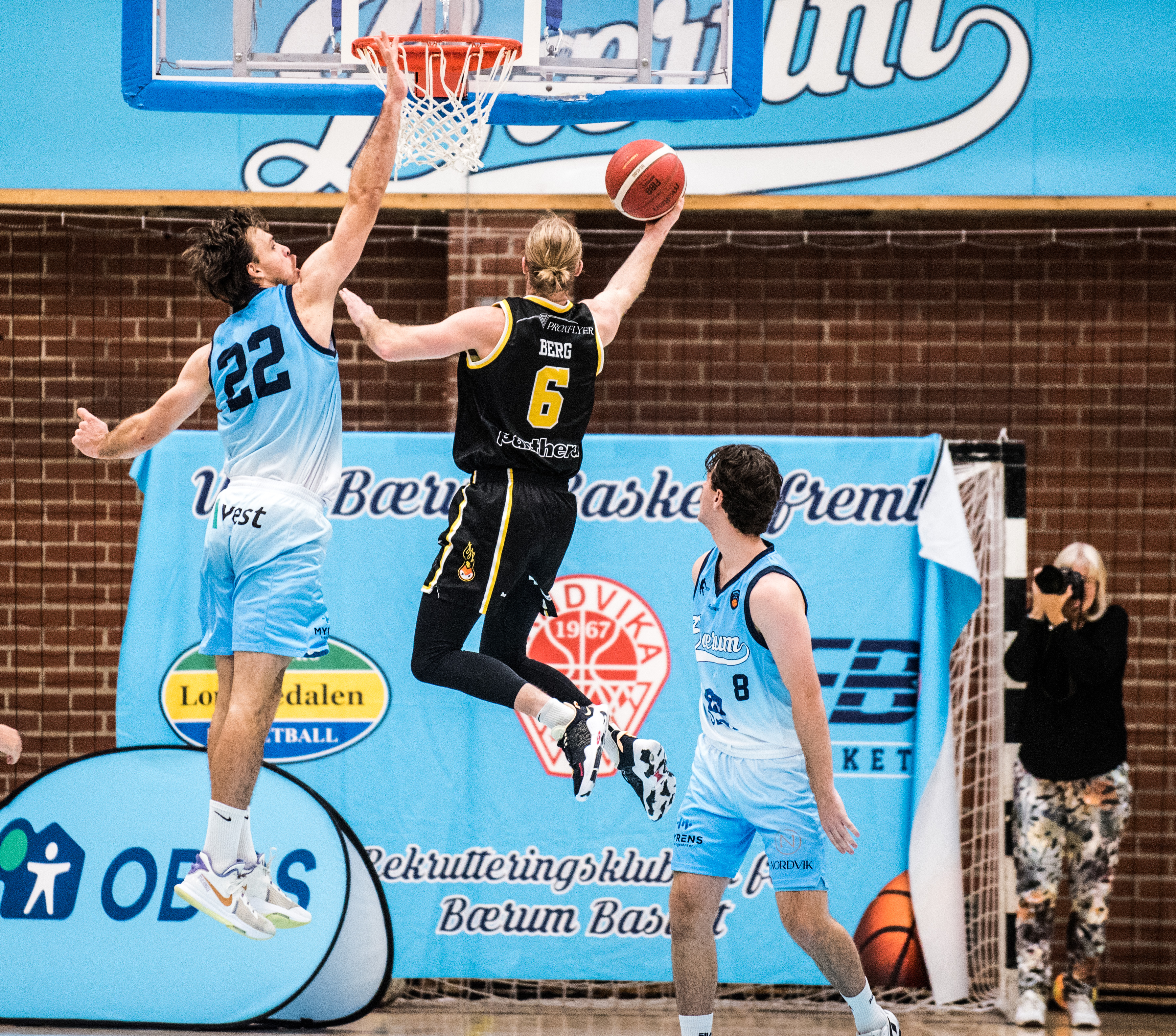 Stian Emil Berg avslutter en lekker slalåm-drive med en layup og scoring mot Sjur Dyb Berg, med Benjamin Alknes Cox til høyre.
FOTO: ERIK BERGLUND  