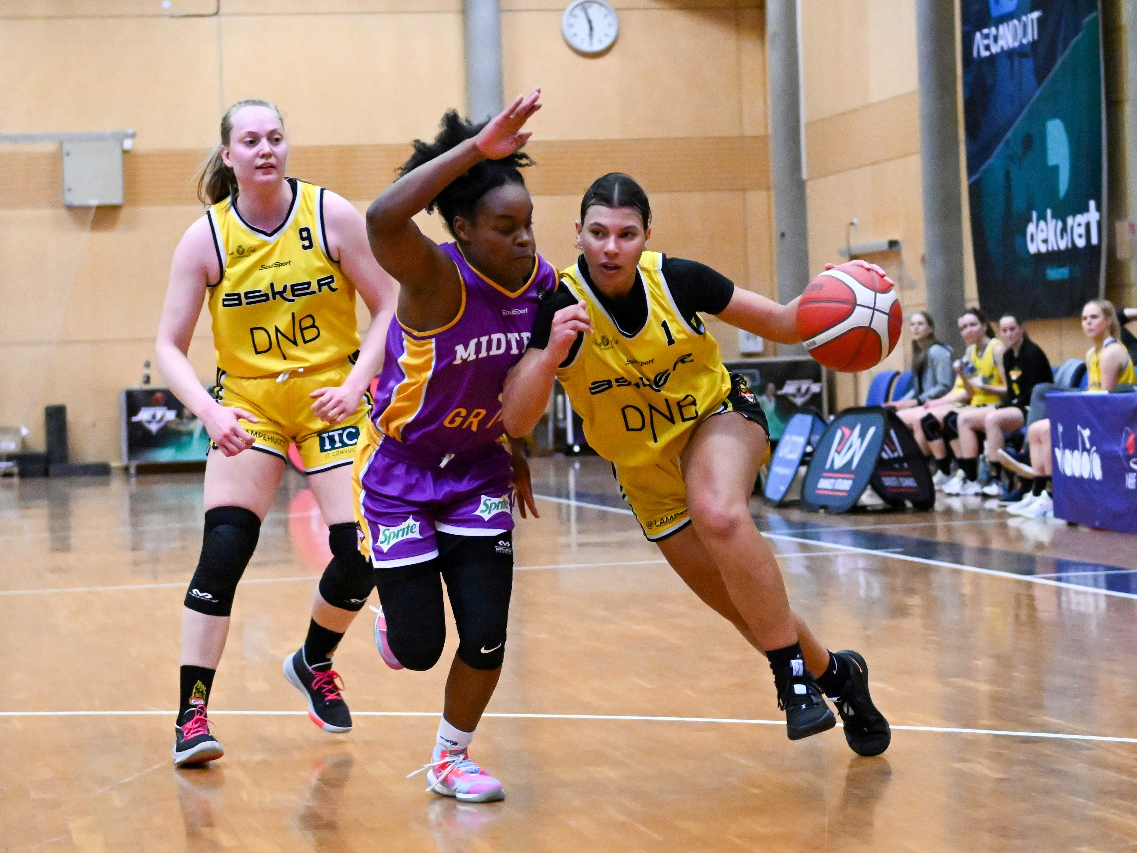 Tayler Bennett i en drive mot Midtbyens amerikanske pointguard Dominique Leonidas i Trondheim Spektrum. Asker Aliens' pointguard er kåret til sesongens beste spiller i BLNO. Bak ser vi Asker-kaptein Siri Granheim.
FOTO: LARS RUNE SKAUG 