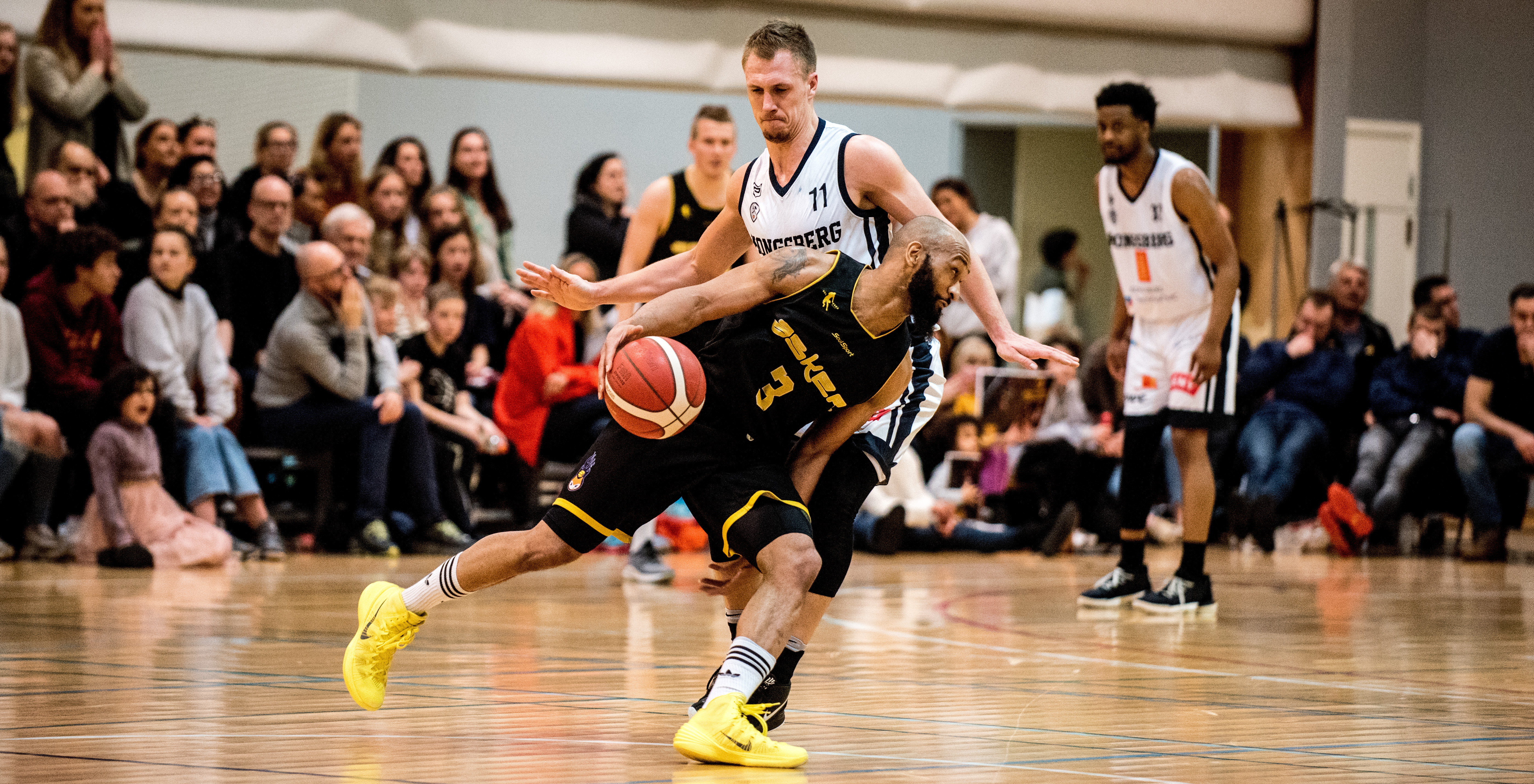 Eric Gilchrese styrte og dominerte for Asker Aliens i Leikvollhallen. Her tar han med seg ballen mot Nikolas Skouen. I bakgrunnen ser vi Robert Hubbs. FOTO: ERIK BERGLUND