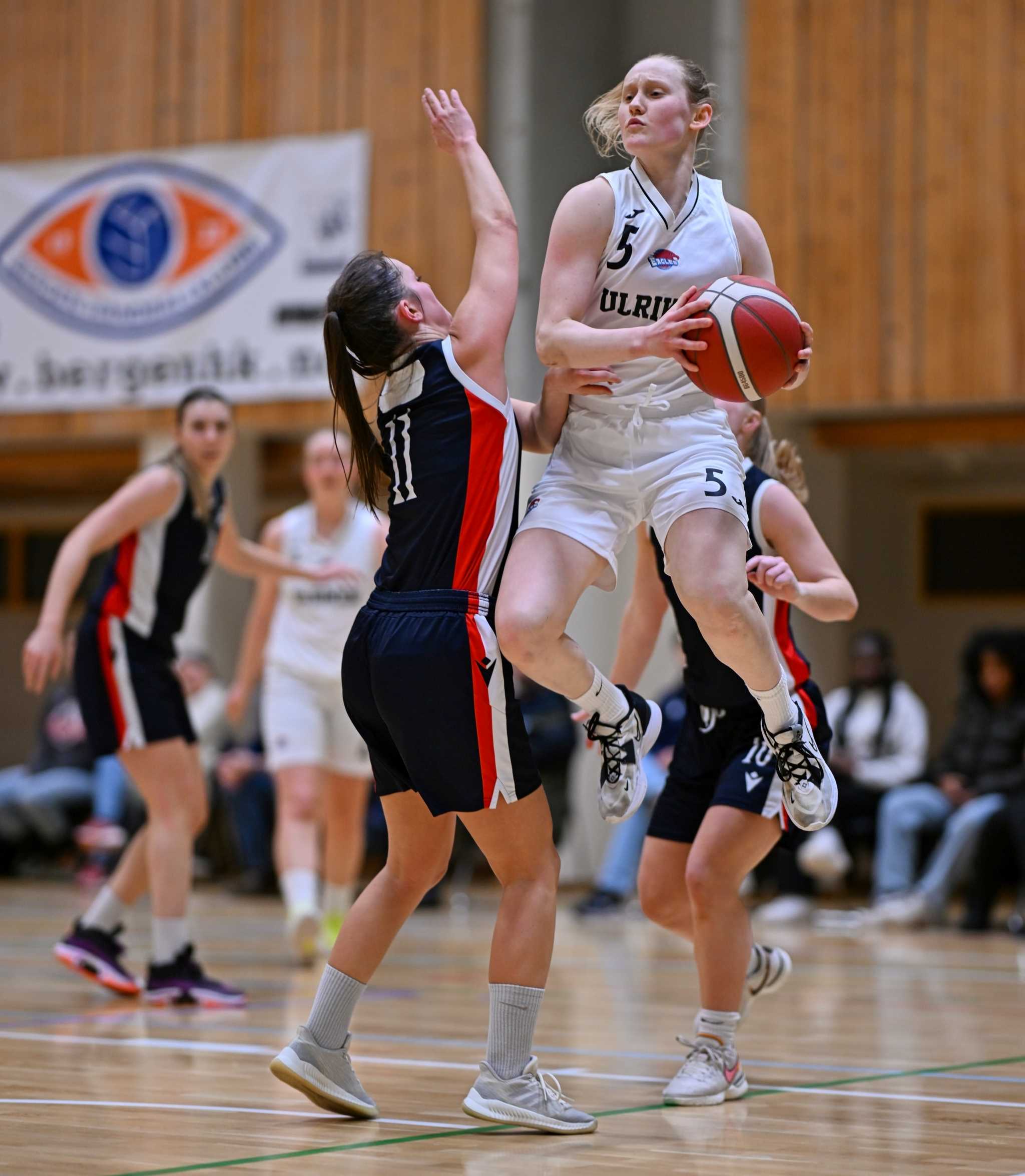 Aurora Sørbye driver inn i Bergen Elite-feltet og legger en pasning, presset av Karoline Falch-Monsen. Ulrikens pointguard var kampens toppscorer og ledende spiller med 21 poeng, 8 assists, 5 returer, 3 steals og ingen turnovers på sine 32 minutter.
FOTO: KJELL EIRIK HENANGER 