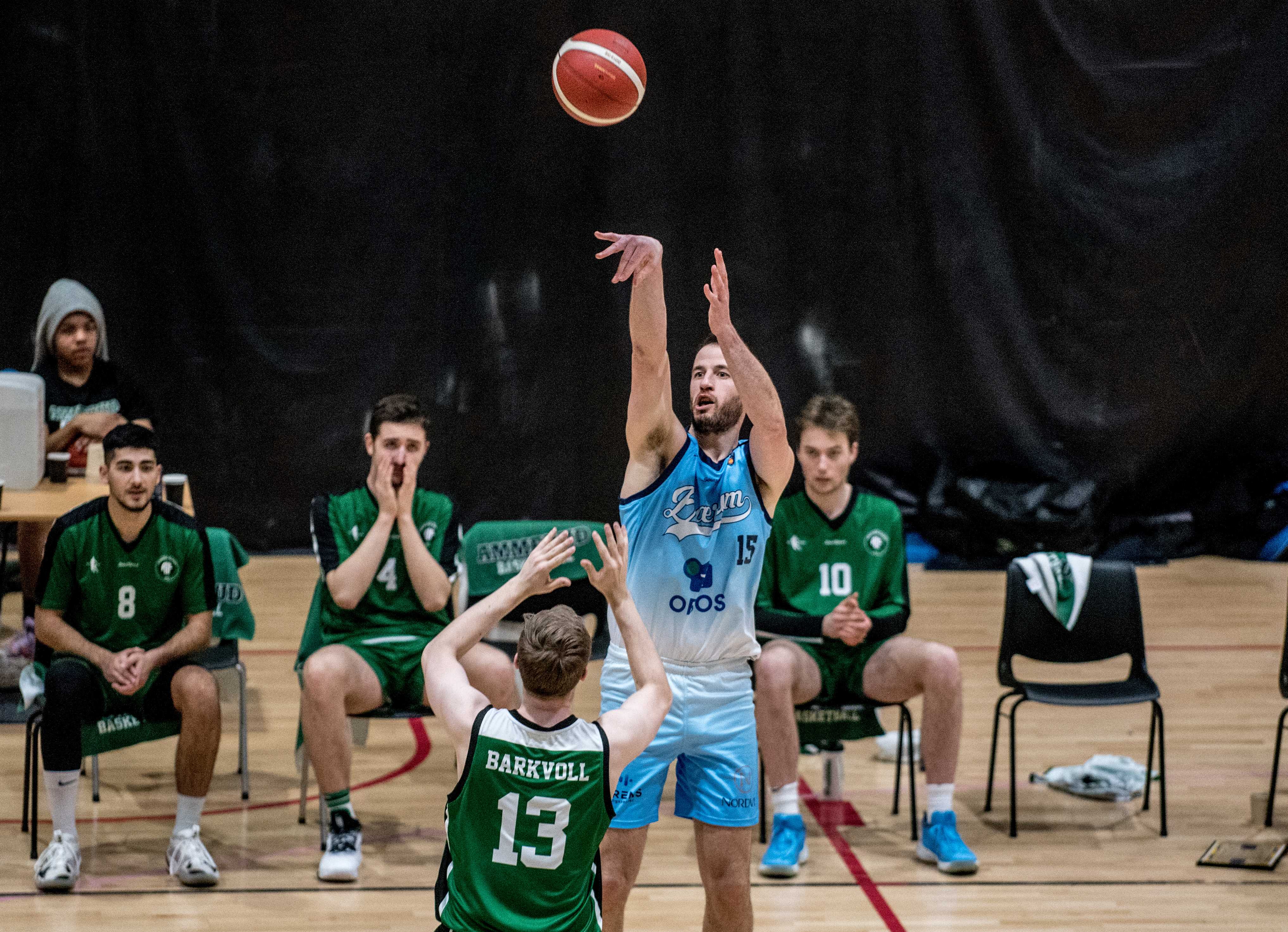 Philipp Schwethelm traff på 4 av 5 trepoengere og endte som toppscorer med 24 poeng for Bærum. Her fyrer tyskeren løs over Aksel Barkvoll. Ammerud-spillerne på stolene bak er fra venstre Ouzhan Farzaneh, Riad Basic og Fredrik Hårstad Trana.
FOTO: ERIK BERGLUND 