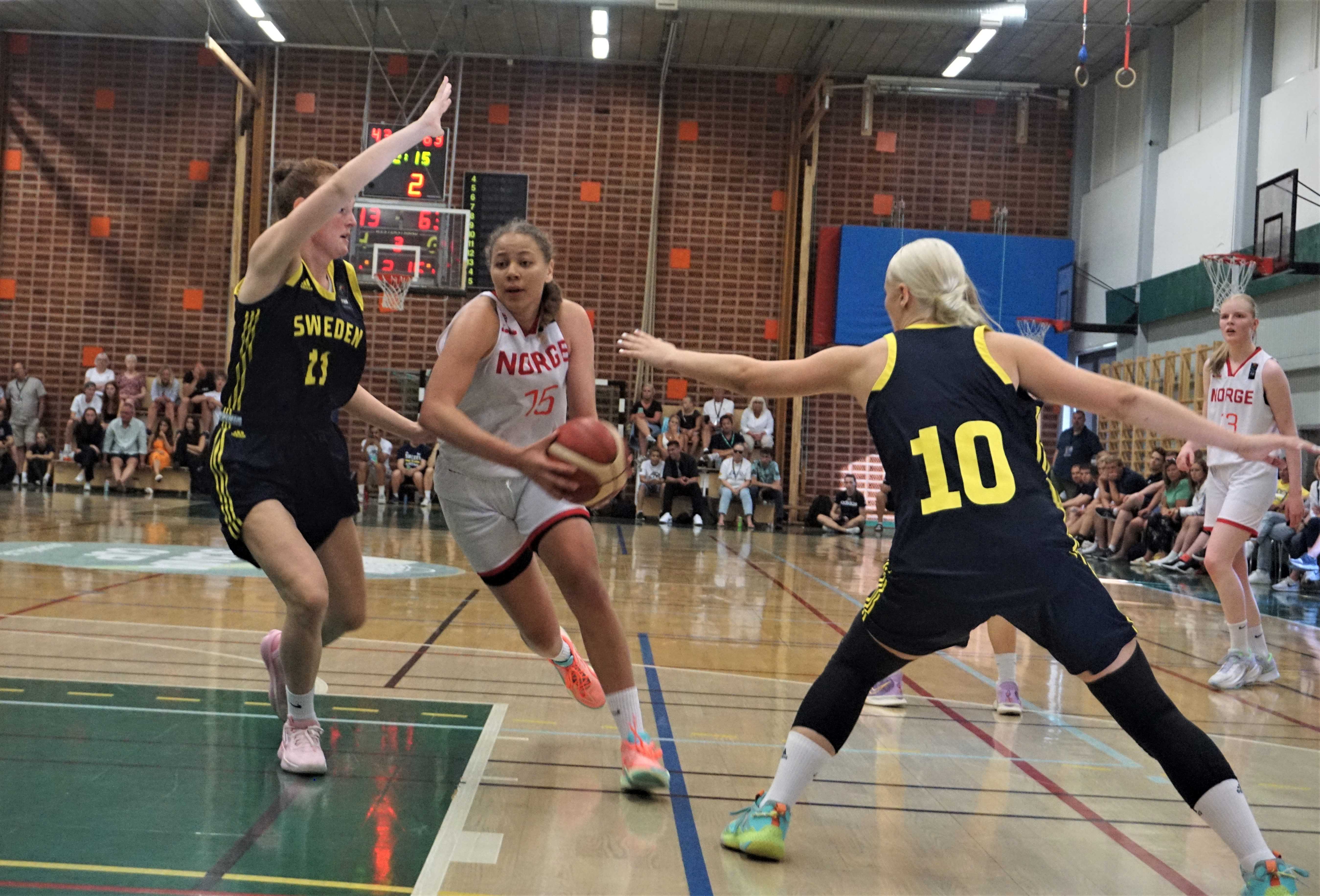 Karyn Sanford har fintet seg fri og driver inn mellom to svenske spillere. U20-landslagets kaptein hadde 15 poeng og 5 assists i lørdagens kamp. Til høyre i bildet er Vilde Havnes.
FOTO: ARILD SANDVEN 