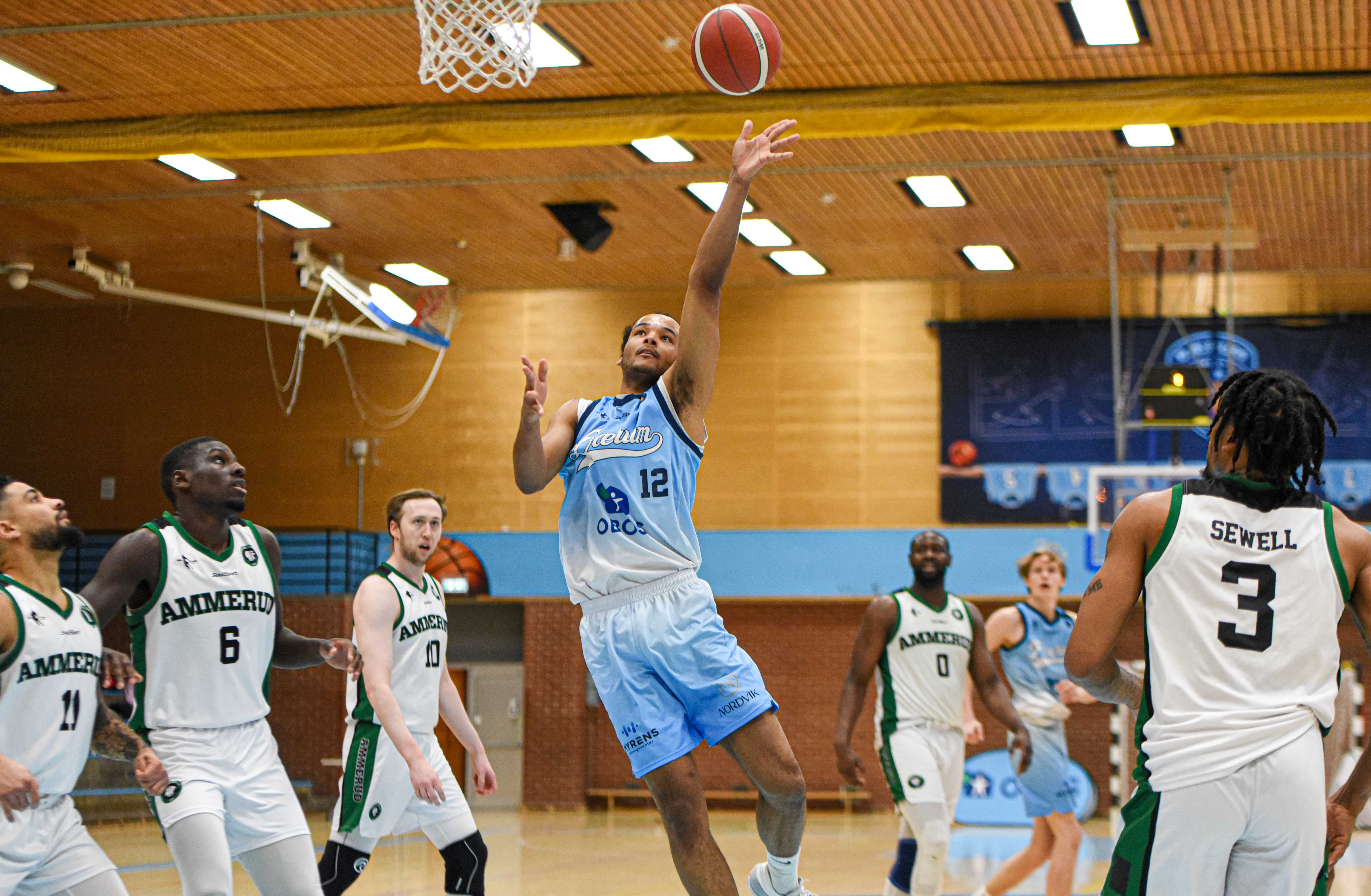 Steffon Mitchell var overalt i tirsdagens kamp mot Ammerud og endte med 24 poeng, 11 returer, 4 assists og 3 steals for Bærum - på 27 minutter. Her er den 2,03 m lange forwarden kommet fri og scorer med alle bortelagets fem spillere rundt seg. Fra venstre ser vi Erick Silva, Mustapha Dibba, Henrik Male Davidsen, Miilah Kombat (bak) og Xavier Sewell.
FOTO: ERIK BERGLUND 