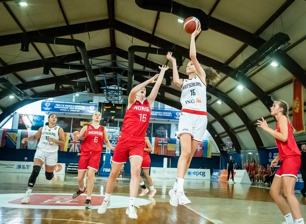 Tysklands ledende spiller Clara Bielefeld flyr forbi Astrid Laugen og legger to av sine 16 poeng i kampen. Den 1,85 m lange guarden hadde også 9 returer, 7 assists, 4 steals og 4 blokker mot Norge. Bak i bildet ser vi Oda Tveiten, til høyre Sofie Hoelsbrekken.
FOTO: FIBA.COM 