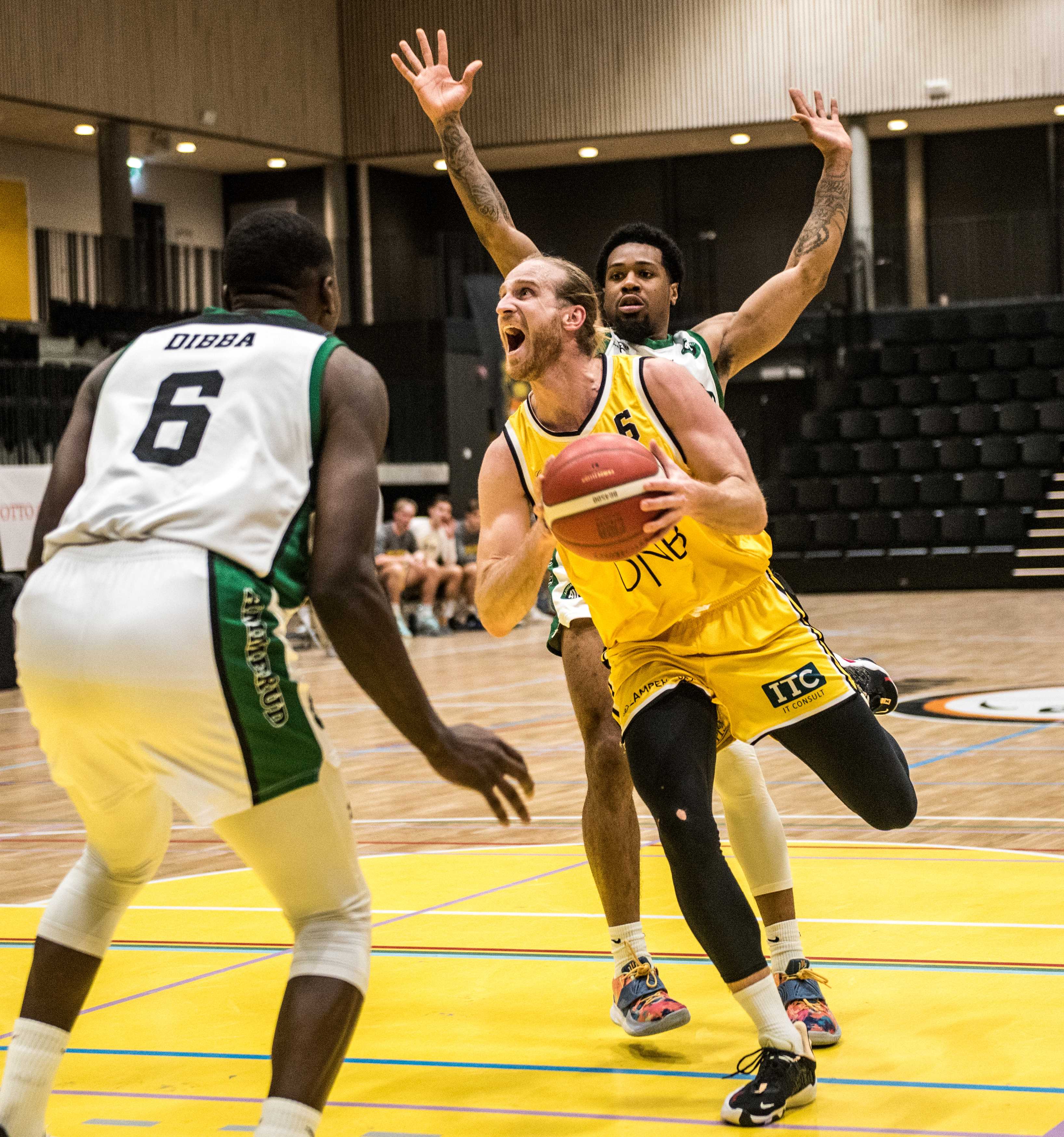 Stian Emil Berg og Asker Aliens lå under med 17 poeng like før pause, men hentet inn alt og vant 80-77 over Ammerud torsdag. Bildet er fra lagenes møte i Leikvollhallen 2. februar og viser Asker-kapteinen i en drive mellom Mustafa Dibba og AJ Harris.
FOTO: ERIK BERGLUND  