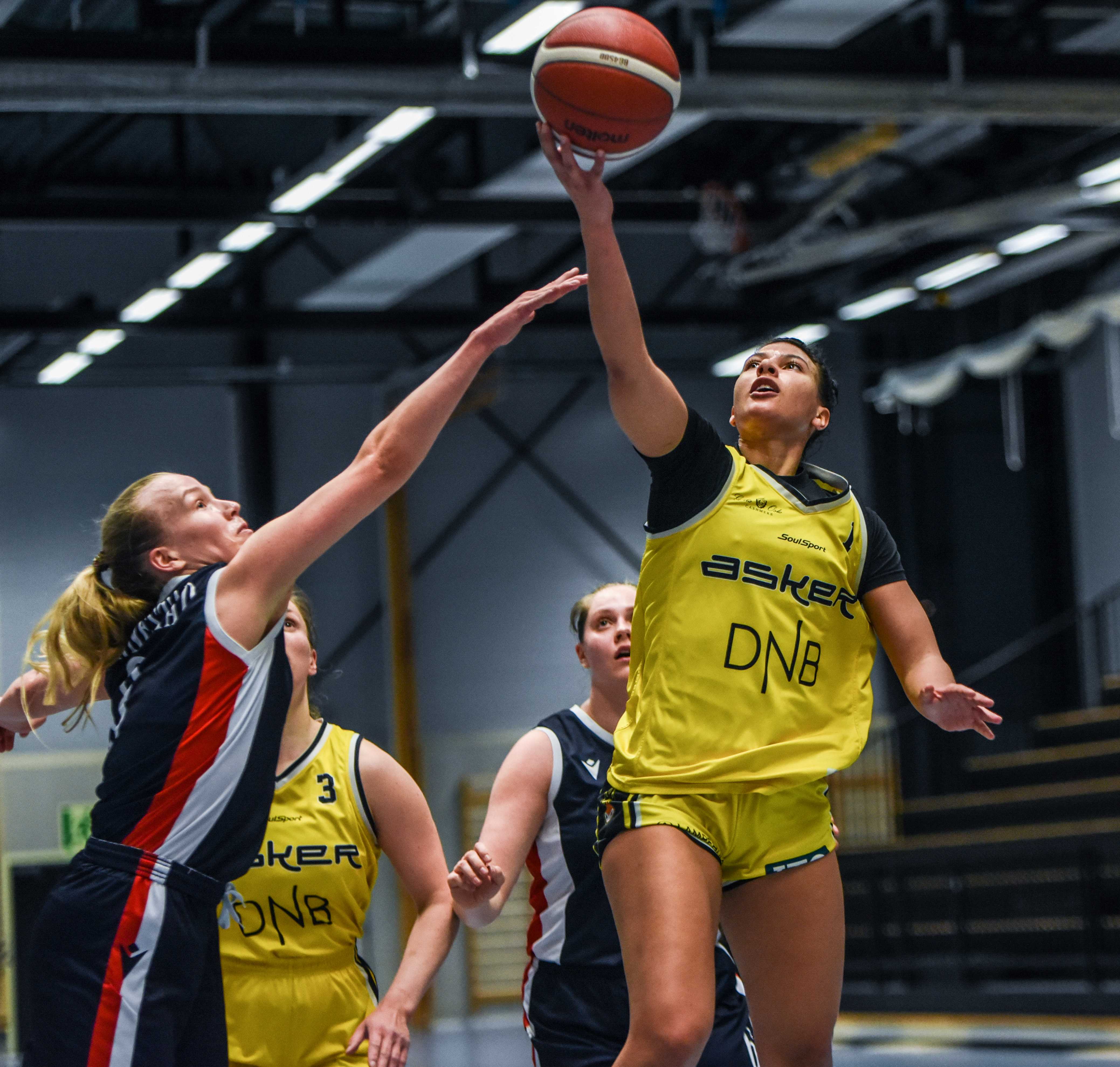 Tayler Bennett hadde 13 poeng, 9 returer, 7 assists og 4 steals da Asker Aliens tok seg til semifinale med 60-38 over Bergen Elite. Her legger ligaens MVP og toppscorer en layup mot Kristin Skåtun Hannestad. Bak ser vi Ingrid Selvik og Rikke Sjumarken.
FOTO: ERIK BERGLUND 