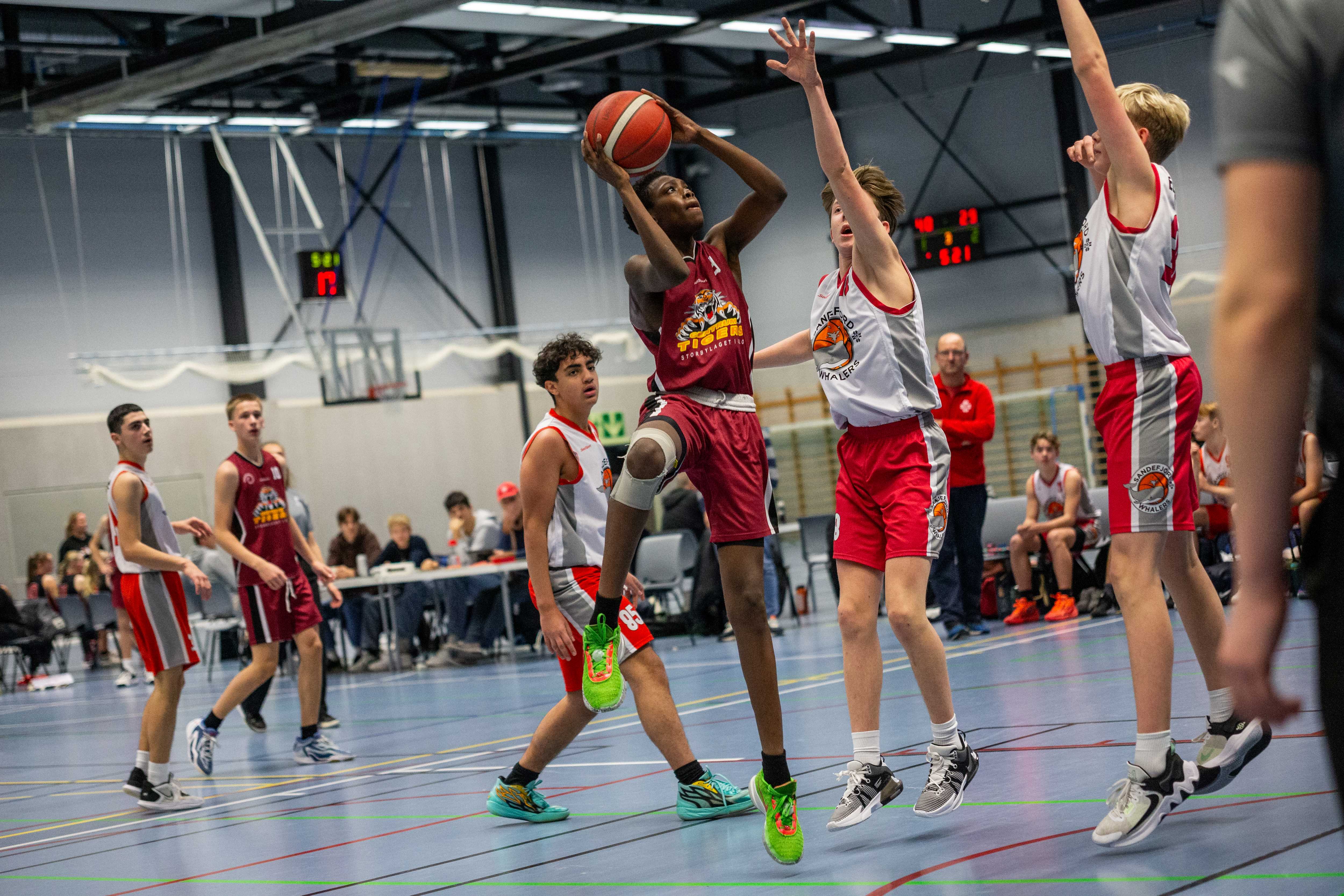 Alexford Obeng fra Centrum Tigers kommer seg fri til en avslutning mot Sandefjords Markus Emil Paulsen og Sigve Furuli Elleflaadt. Centrum vant alle sine tre kamper i U16-kvalifiseringen og avsluttet med 98-46 over Sandefjord. De tre spillerne bak i bildet er fra venstre Leon Kurtishi, Leon Severin Kelp og Yonus Abdullah Khabas. 
FOTO: SIMEON BACOLOD 