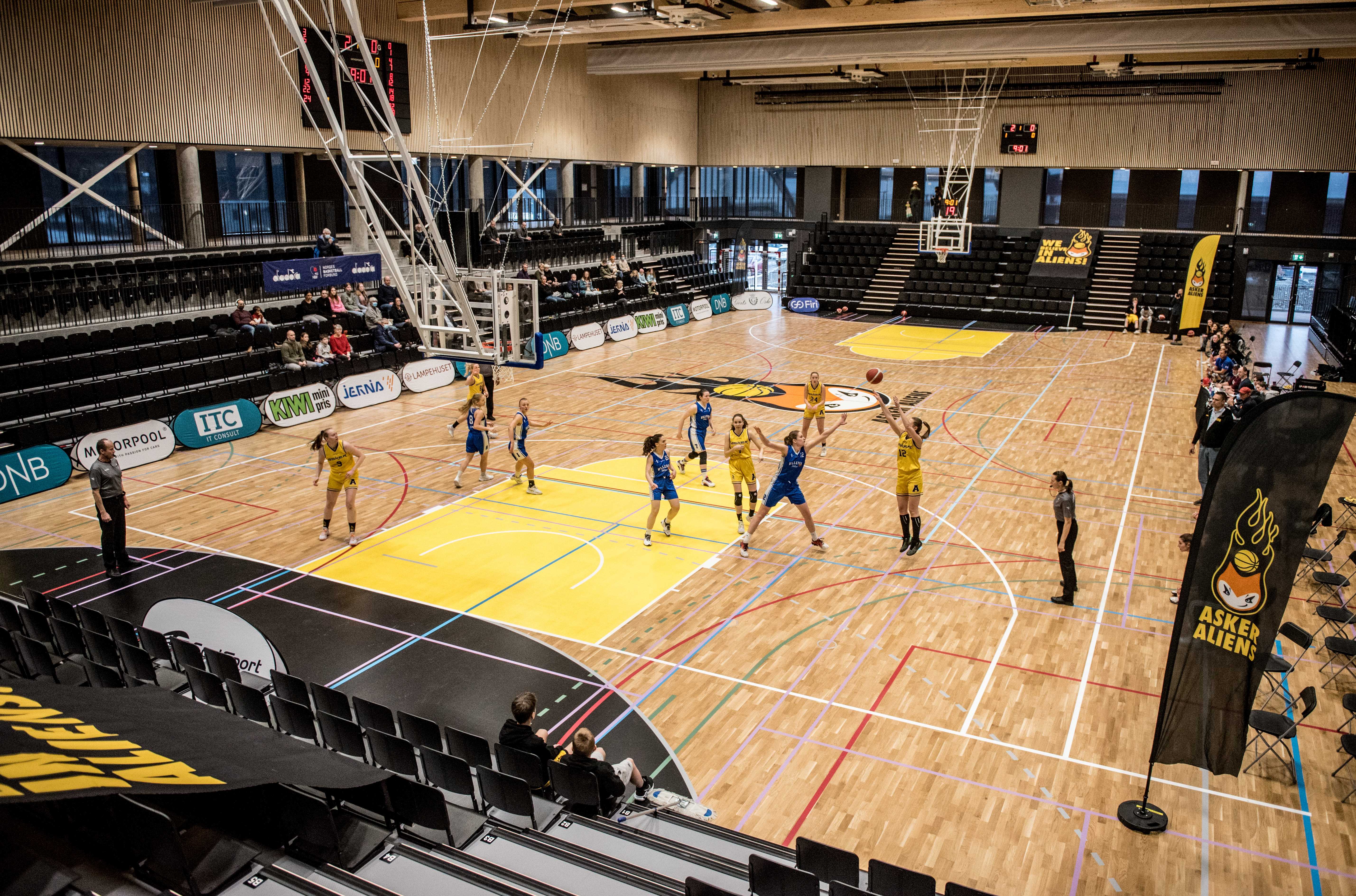 Asker Aliens og Ullern spilte den første kampen i Nye Leikvollhallen, eller Leikvoll C som den inntil videre heter. En arena med perfekt lys, lekker parkett og tribuner på alle kanter. Nede på banen er det Karianne Øysted Sørbye som skyter over Tori Solberg Halvorsen.
FOTO: ERIK BERGLUND   