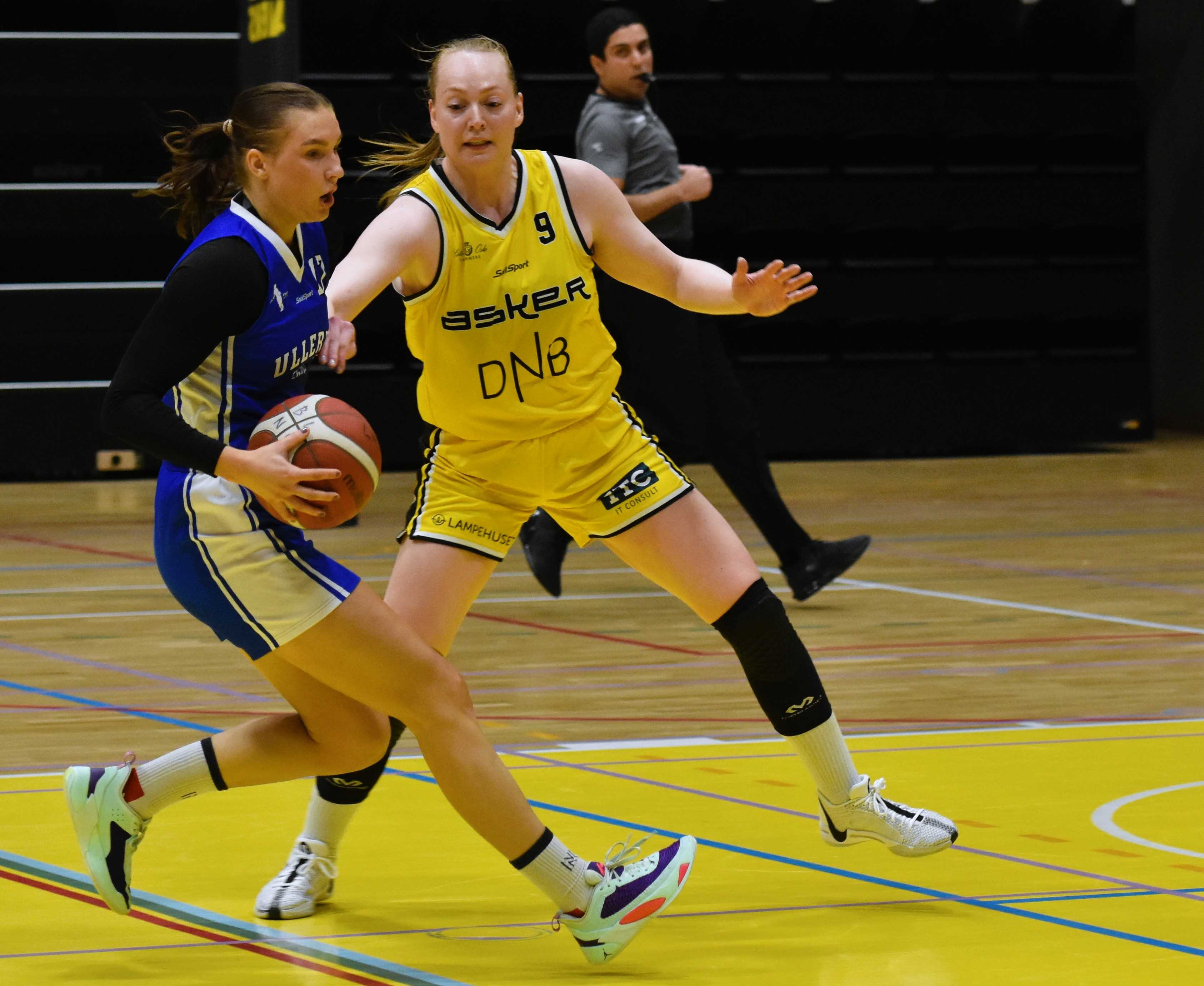 To av de ledende spillerne i Leikvollhallen: Maren Mildestvedt som hadde 16 poeng og spilte solid forsvar for Ullern, her med ballen mot Asker-kaptein Siri Granheim - kampens toppscorer med 25 poeng etter 7 av 14 på trepoengere. Bak ser vi dommer Yousuf Sultany.
FOTO: MARIANNE MAJA STENERUD 