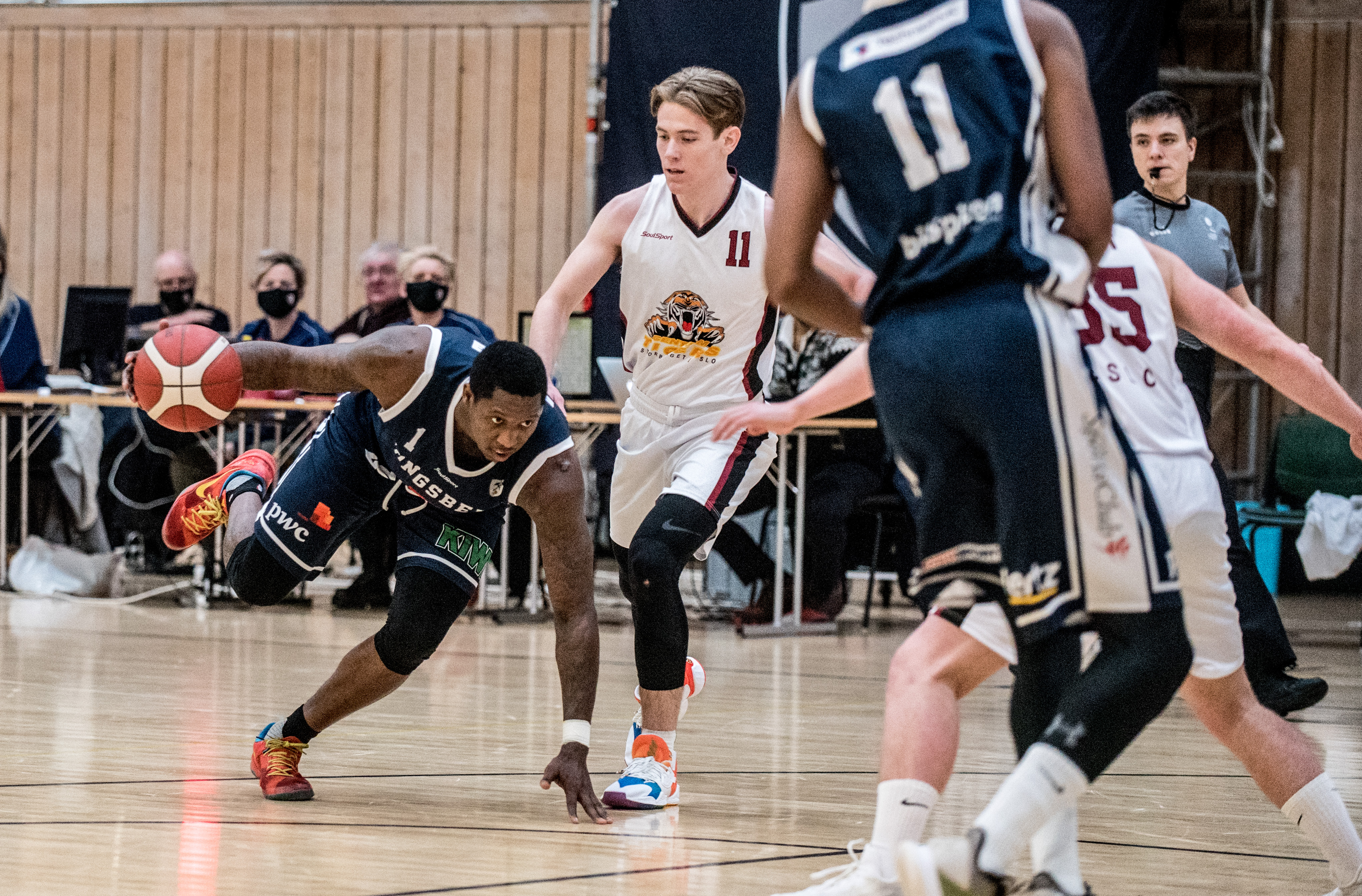 Fred Thomas må nedpå med en hånd, men beholder kontroll over ballen mens han prøver å komme seg løs fra Centrums Sigurd Sandlie. Bak til høyre følger dommer Sturla Sand situasjonen.
FOTO: ERIK BERGLUND   