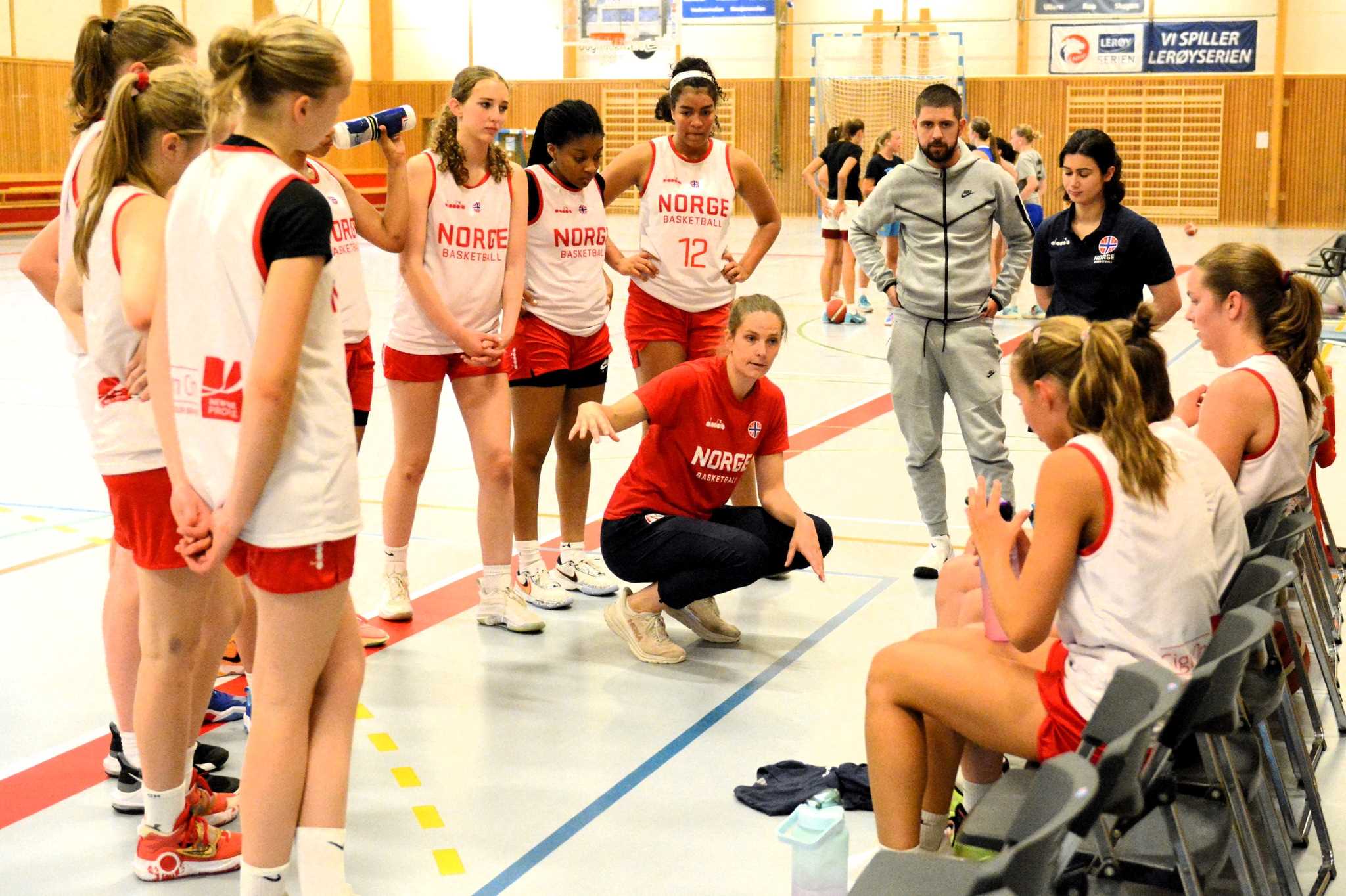 U16-jentene i en timeout under en treningskamp i Ørakerhallen før avreise til B-EM i Podgorica. Head coach Tori Solberg Halvorsen forklarer og bak henne ser vi fra venstre Solveig Ulveseth, Gemima Lesole Nkanga, Andrea Fergem Faal og assistent-trenerne Isak Prinos og Dana Meknas.
FOTO: MARIANNE MAJA STENERUD 