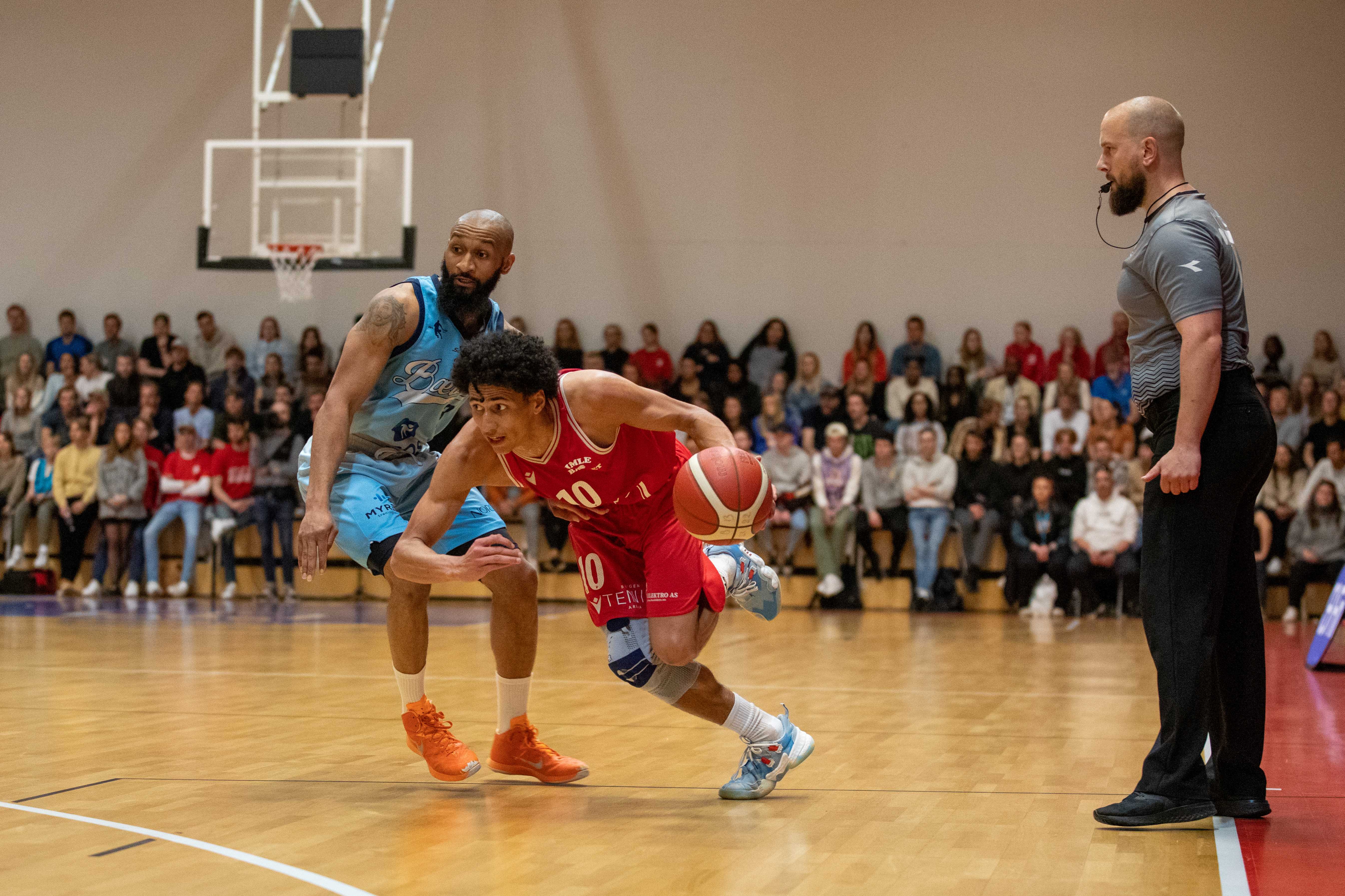 Lars Fredrik Espe hadde 26 poeng og var avgjørende for Gimle med steals og scoringer i sluttminuttene. Her driver pointguarden forbi Eric Gilchrese, mens dommer Simon Nordeide følger situasjonen.
FOTO: BRAGE TITLESTAD 