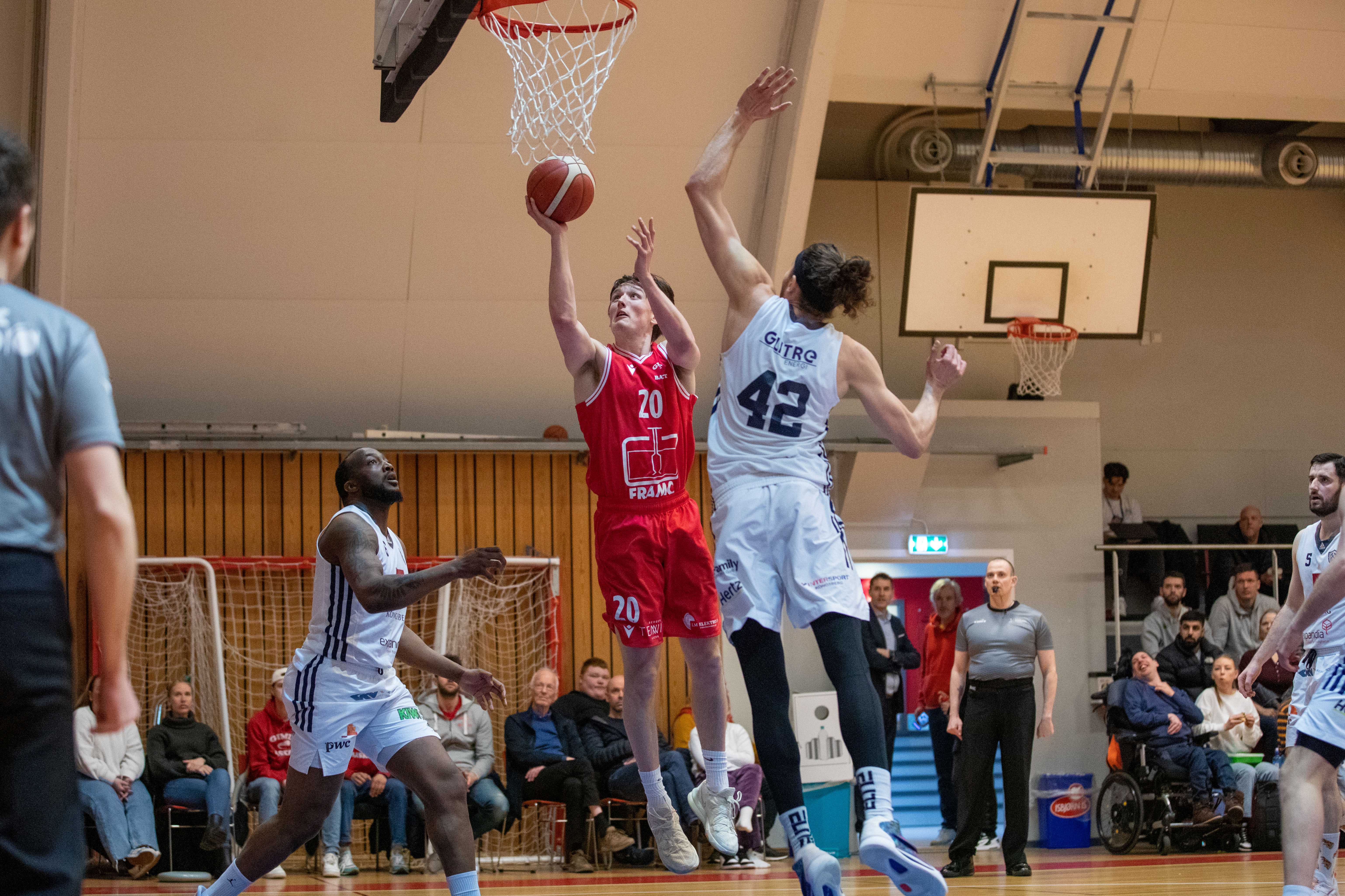 Eivind Lamo var tilbake etter hjernerystelse, spilte for første gang i semifinalene og var en viktig årsak til at Gimle slo Kongsberg Miners 86-65. Her legger hjemmelagets forward to av sine 16 poeng mot Marin Mornar. Til venstre er Djo Loo Yele, bak ser vi dommer Alexander Reiertsen.
FOTO: BRAGE TITLESTAD 