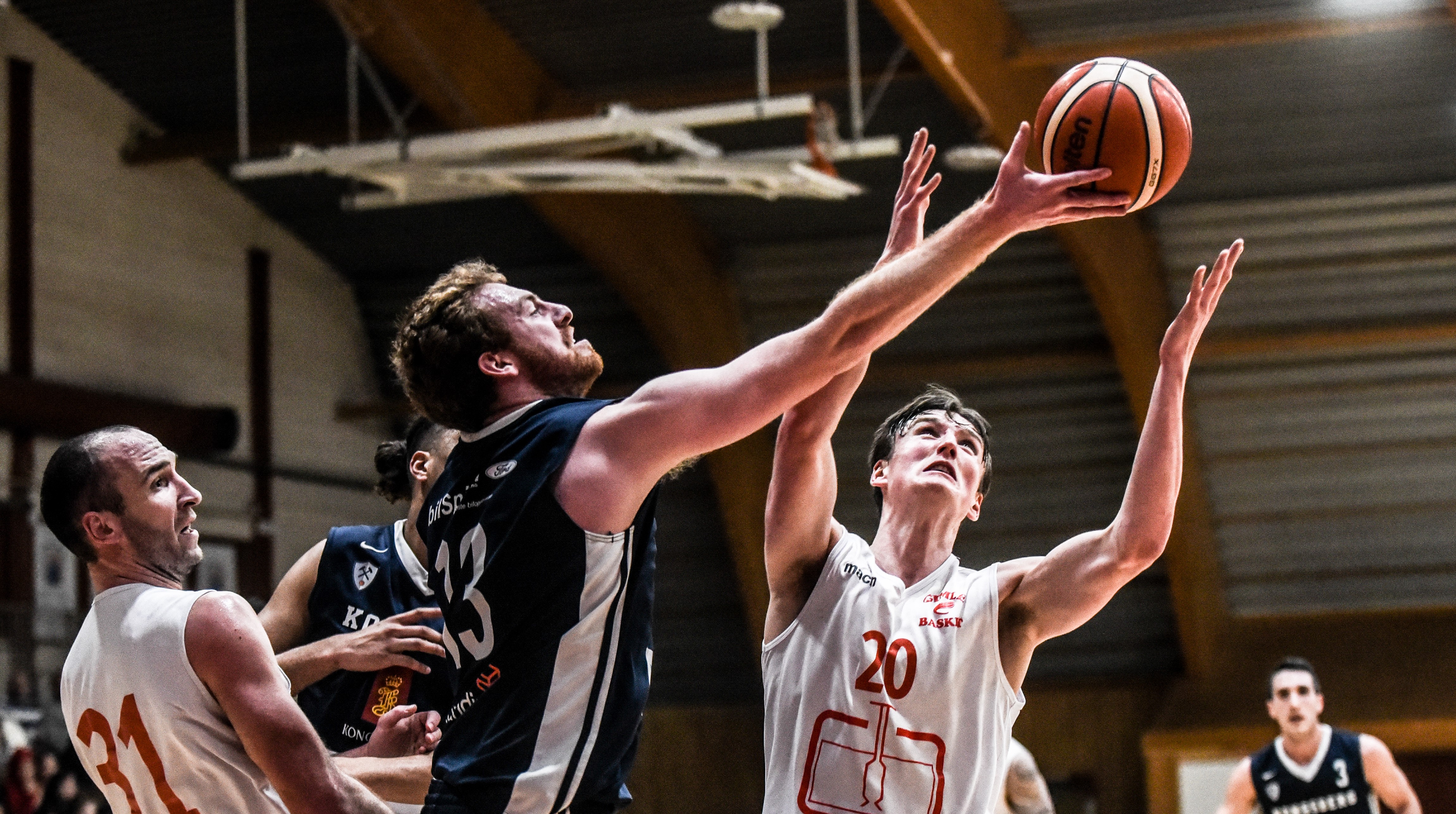 Petar Kutlesic ser ut til å nå ballen foran Eivind Lamo, i et bilde fra det første seriemøtet mellom Kongsberg Miners og Gimle denne sesongen. Milovan Savic til venstre, Aly Hudgins skjult bak Kutlesic og Juan Ferrales til høyre. FOTO: ERIK BERGLUND