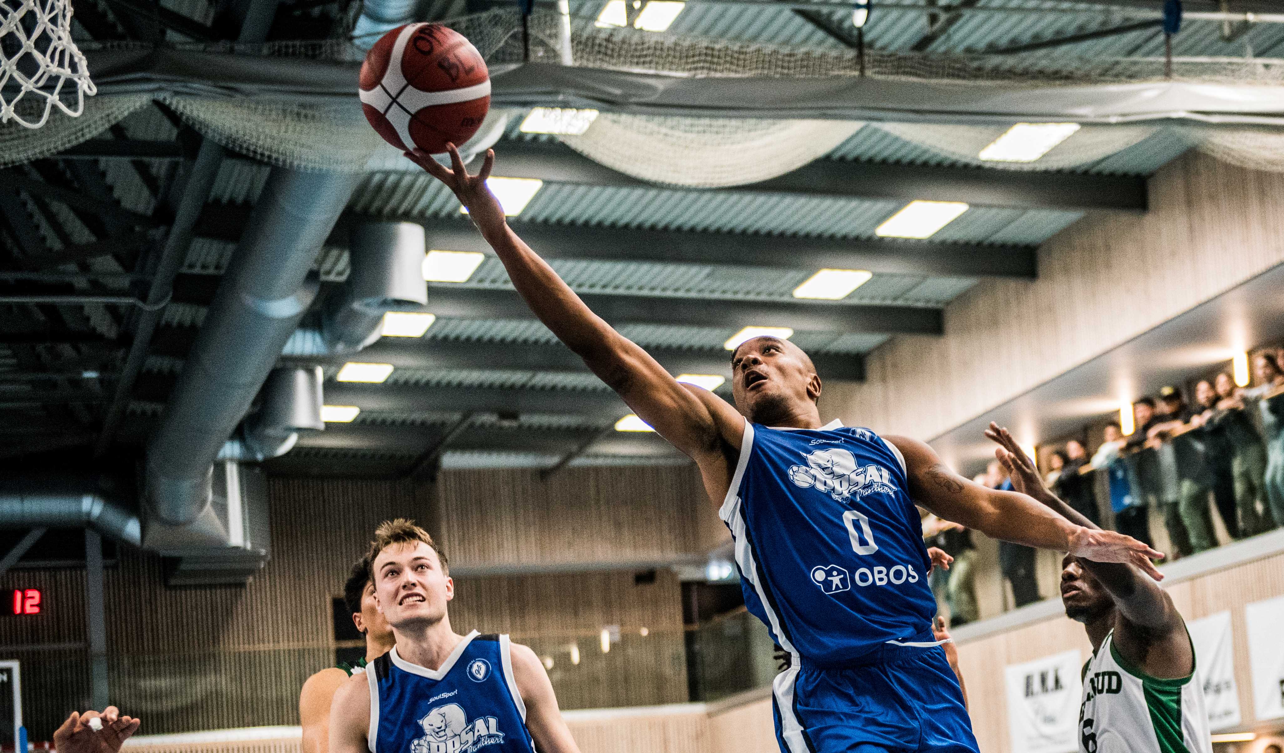 Thomas Ble har driblet seg gjennom Ammerud-forsvaret og legger to poeng for Oppsal. Fredrik Trana til venstre i bildet, Mustafa Dibba til høyre.
FOTO: ERIK BERGLUND 