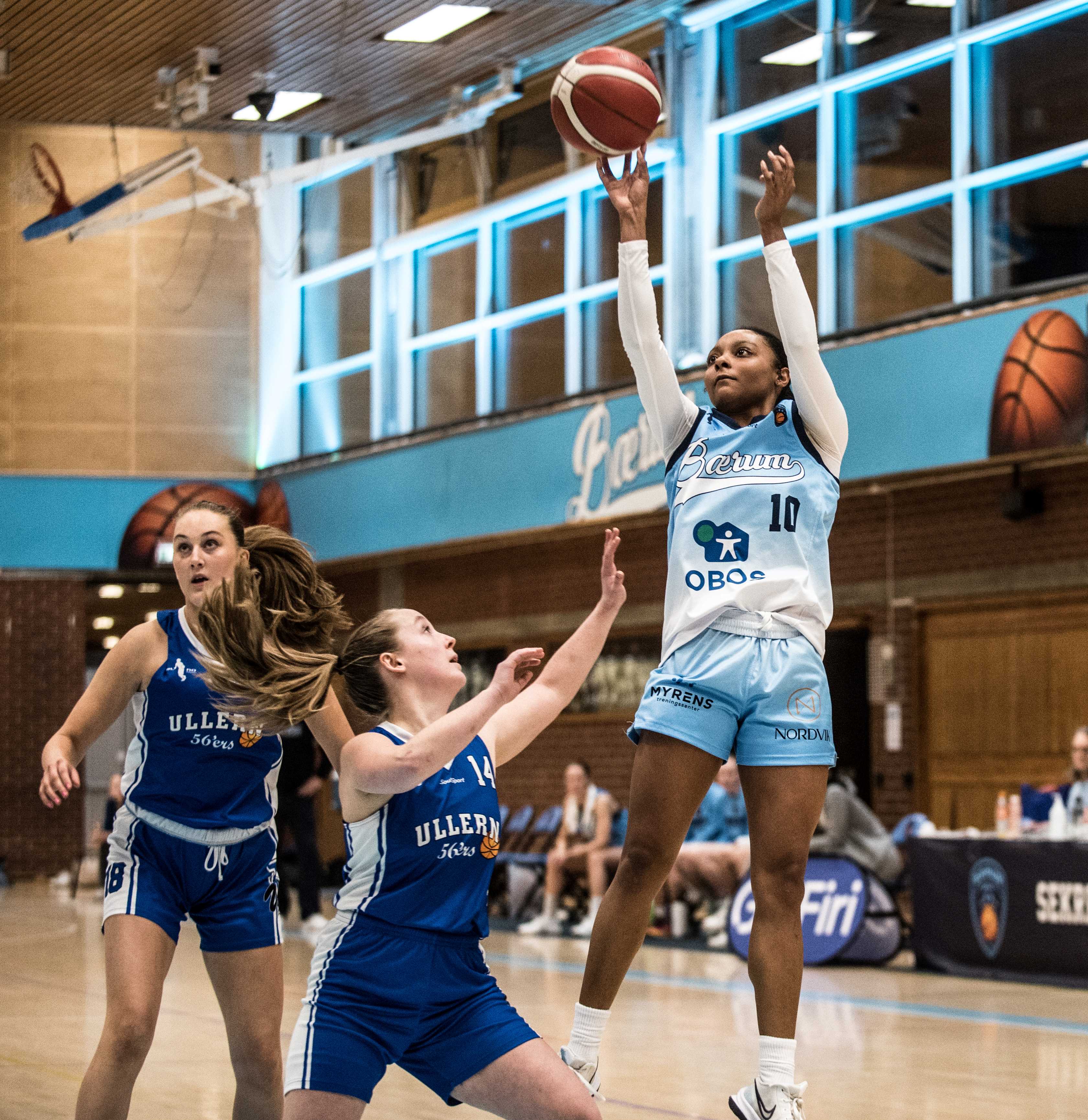 Raziyah Farrington høyt oppe på skudd mot Ullern, med Marika Kromberg (nr 14) og Hannah Ledsten-Ullersmo i forsvar. Bærums amerikanske guard er kåret til sesongens MVP i Firi-ligaen og var også toppscorer med 23,2 poeng pr. kamp og er sesongens nummer 2 i assists, 6 i returer og 2 i effektivitet.
FOTO: ERIK BERGLUND 