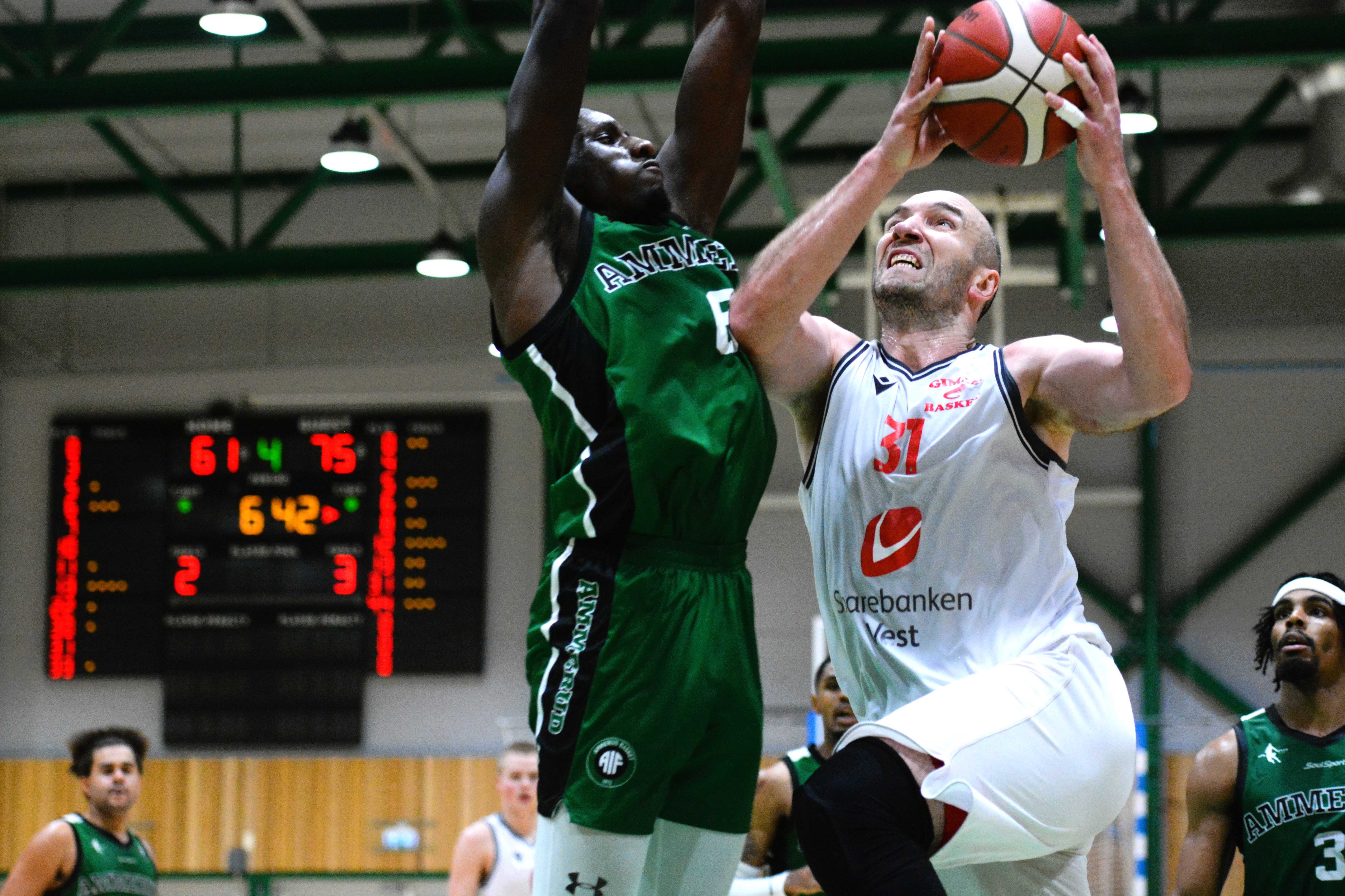 De to ledende spillerne i Apalløkkahallen i duell, Milovan Savic i skuddet og Mustafa Dibba i forsvar. Savic var kampens toppscorer med 29 poeng, hadde i tillegg 16 returer og 6 assists og avgjorde kampen for Gimle med 6 av 6 på straffer de siste 40 sekundene. Dibba var Ammeruds ener med 21 poeng og 7 returer.
FOTO: MARIANNE MAJA STENERUD 