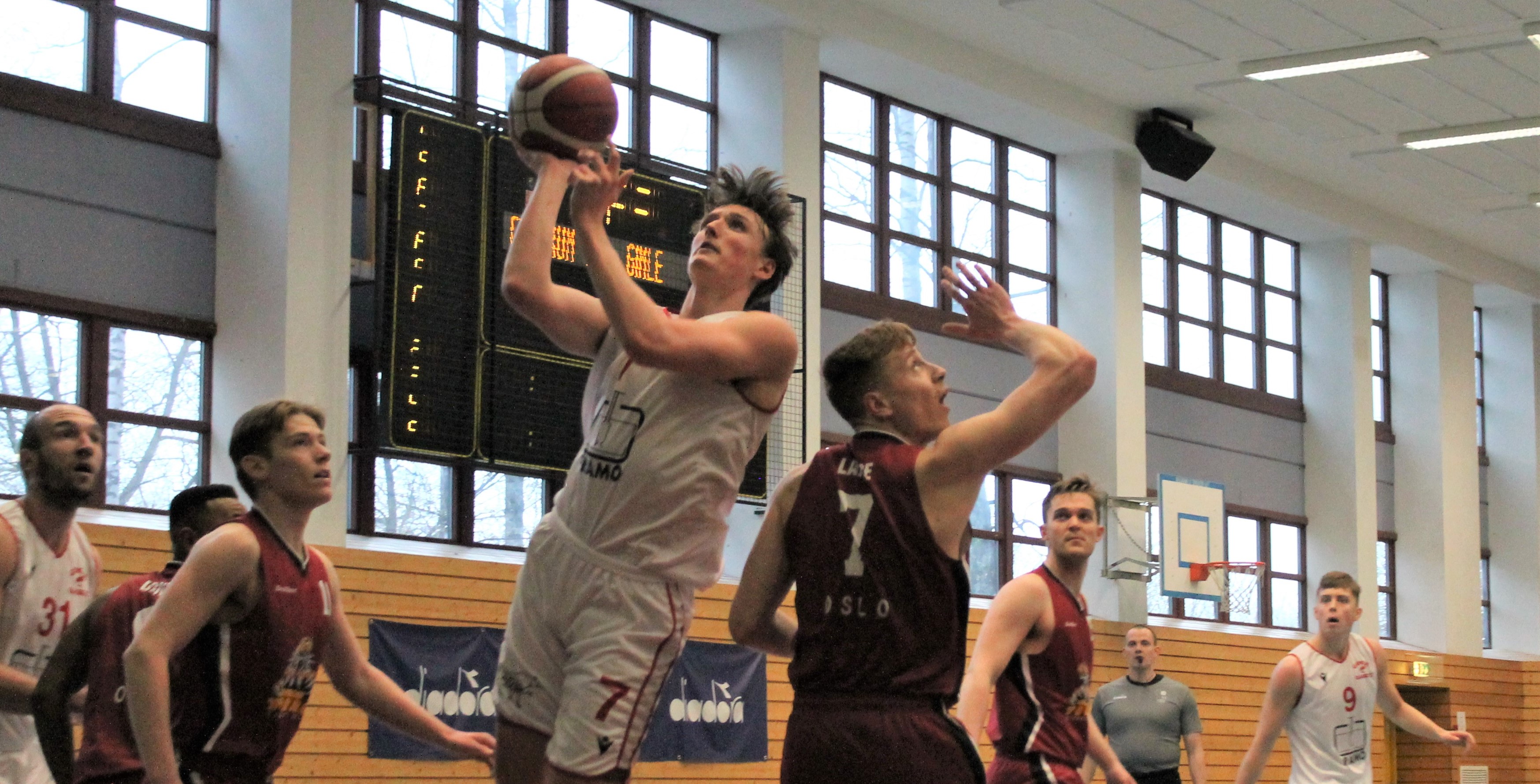 Eivind Lamo har satt fart på Gimle etter at han kom tilbake fra spansk basket og to måneders skadeavbrekk. Mot Centrum Tigers lørdag bidro landslagsforwarden med blant annet 16 poeng, 6 returer og 4 steals. Her går han opp og scorer mellom Sigurd Sandlie (til venstre) og Henrik Lange. Til venstre i bildet ser vi Milovan Savic og Akrem Dagnew (delvis skjult), til høyre Sander Aslesen, dommer Alexander Reiertsen og Adam Johansson. FOTO: ARILD SANDVEN