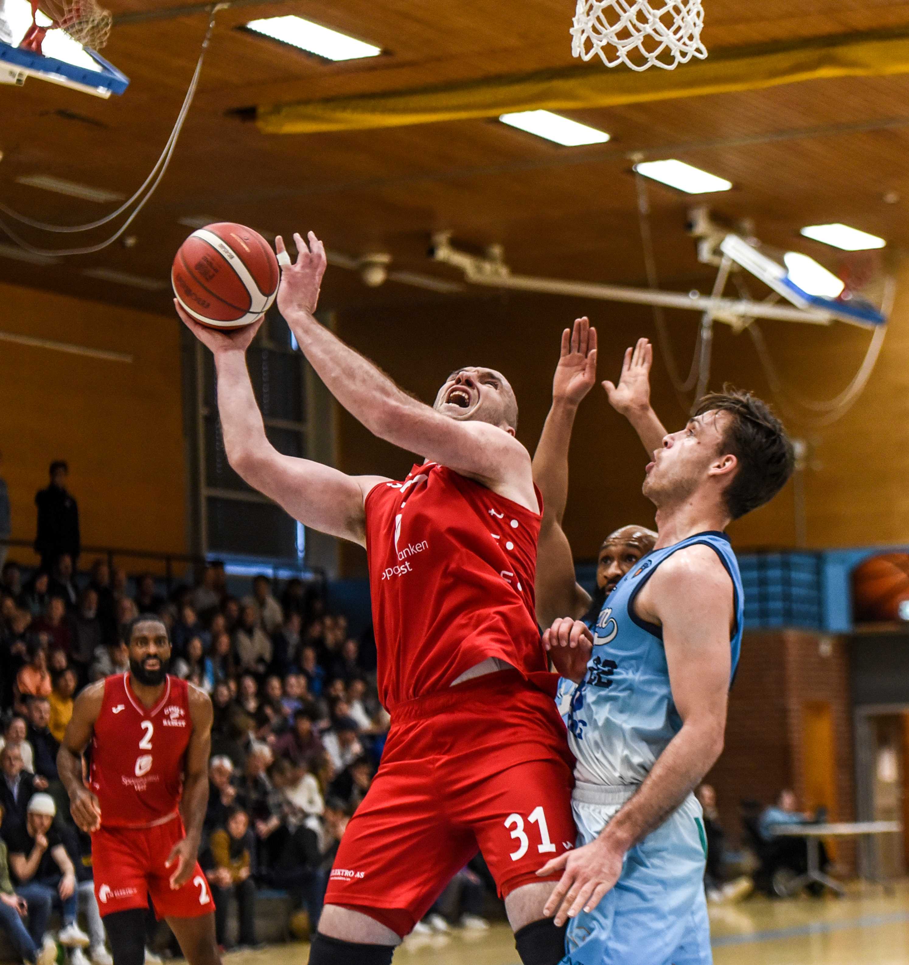 Milovan Savic spilte bare 8 minutter, men la 12 poeng og var en viktig mann da Gimle dro fra Bærum i fjerdeperioden. Her går han sterkt opp mot Sjur Dyb Berg og scorer i sitt første innhopp i første periode. Bak ser vi Dante Thompson.
FOTO: ERIK BERGLUND 