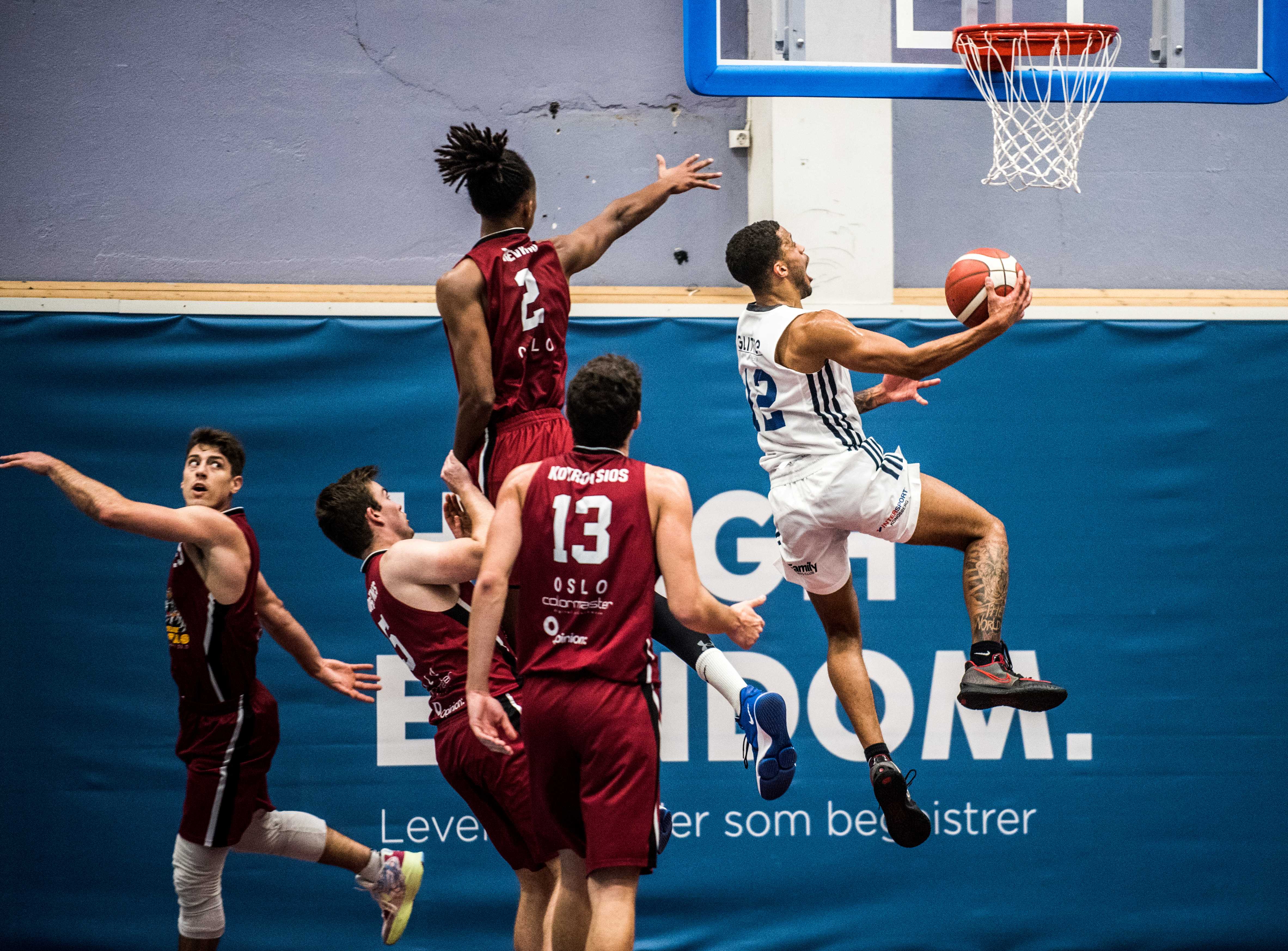 William Lybæk var overalt i Vulkanhallen og ble kampens toppscorer med 26 poeng. Her har han lagt hele Centrum Tigers-forsvaret bak seg og legger inn en ny scoring. Oliver Bojang Visnes (Kongsberg Miners i fjor) forsøker å stoppe ham, mens de øvrige spillerne er Pat Dickert (til venstre), Øyvind Torsetnes og Giorgos Kotrotsios.
FOTO: ERIK BERGLUND 