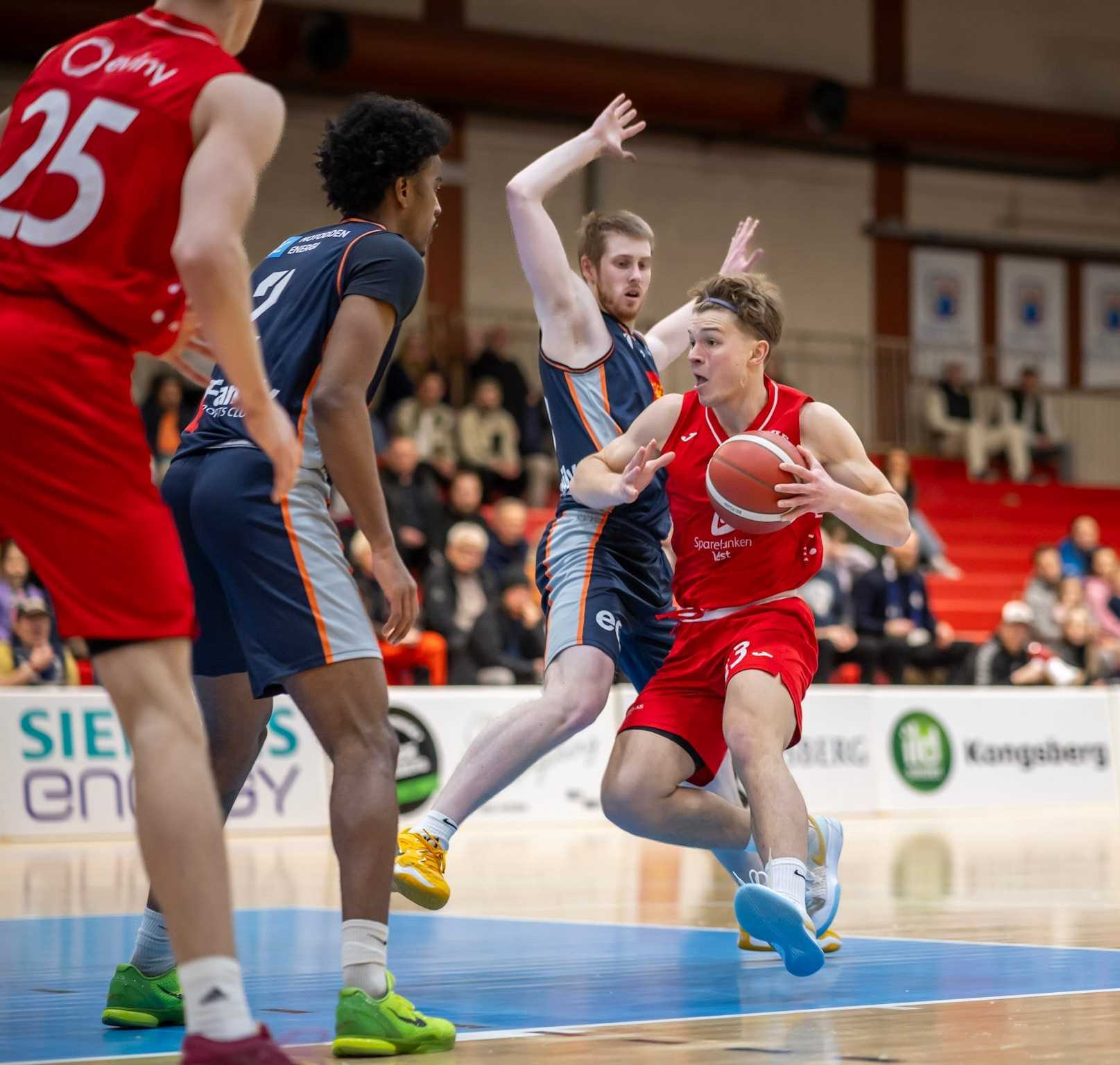 Reidar Greve hadde 18 poeng og 7 returer for Gimle - og la den viktige trepoengeren til ledelse 79-75  med 1:55 igjen å spille i Kongsberghallen. Her utfordrer han Tobias Rotegård, mens også Jordan Roberts står klar i forsvar for hjemmelaget.
FOTO: ESPEN SANDENGEN 