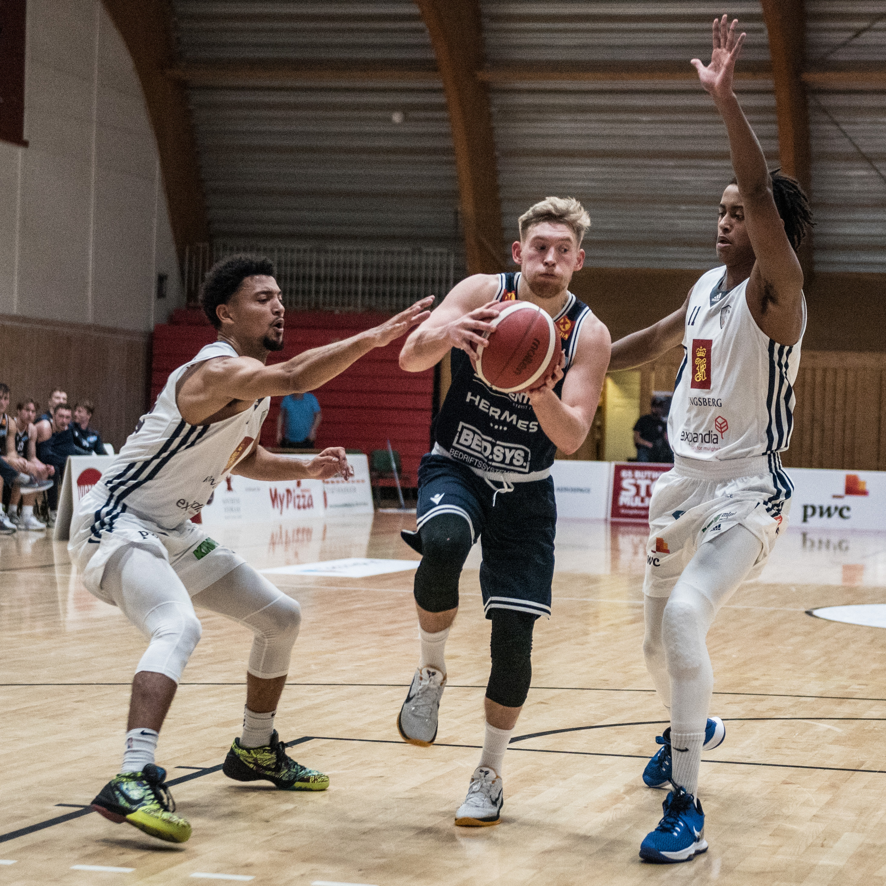 Johannes Lange var toppscorer med 24 poeng, traff 5 av 6 trepoengere og var sentral med både trepoengstreff, straffebom og straffetreff da Tromsø Storm slo Kongsberg Miners 86-81 etter overtime søndag. Bildet er fra lagenes møte i Kongsberghallen 31. oktober, da Tromsø Storm vant 78-73. Her er lagkaptein Lange i en drive mellom Bryan Alberts (til venstre) og Oliver Bojang Visnes.
FOTO: ERIK BERGLUND  