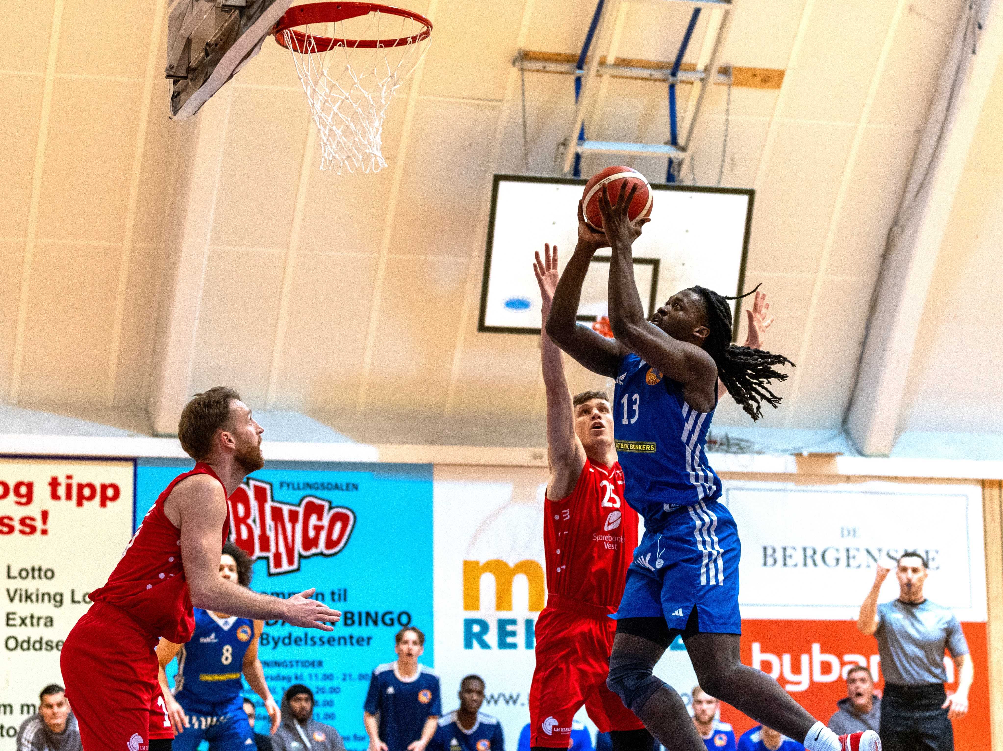 Isaac Likekele, U19-verdensmester med USA i 2019, noterte seg for enda en triple-double: 21 poeng, 13 returer og 10 assists da Fyllingen slo Gimle 88-79. Her går han sterkt opp mot Hallvard Venstad Staff. Til venstre ser vi Mikkel Kolstad.
FOTO: BRAGE TITLESTAD 