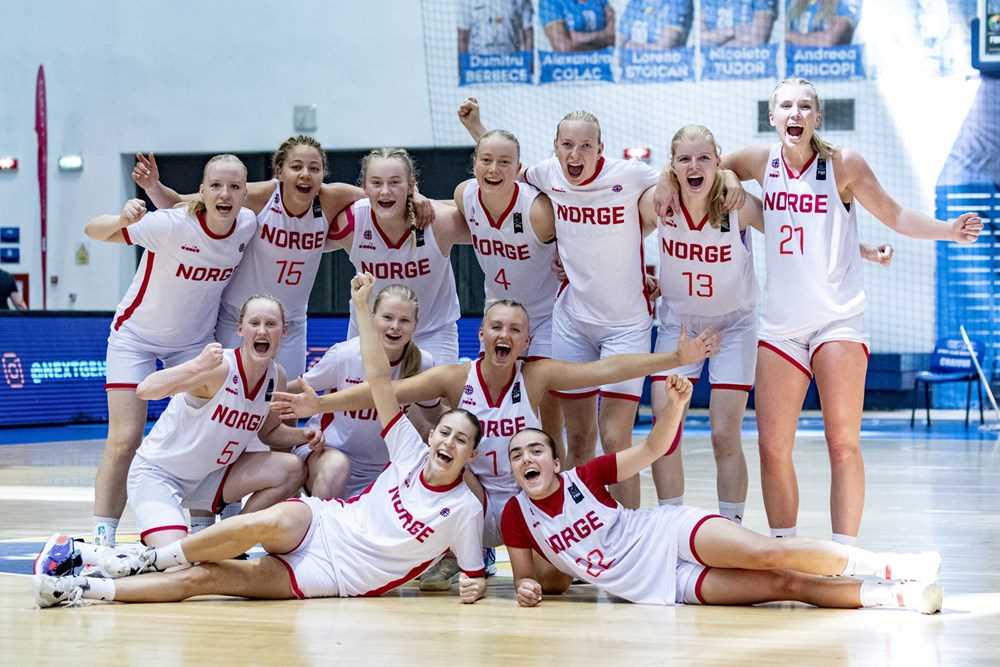 Jublende U20-jenter etter den femte seieren på sju kamper, 83-75 over Irland som sikret norsk 7.- plass i B-EM i Craiova. Foran ligger Sophia Priestley (til venstre) og Fatima Mohammad, i neste rekke sitter Aurora Sørbye (til venstre), Selma Deisz og Felicia Dyngeland-Sundén, bak fra venstre er Anna Hovig Wikstrøm, Karyn Sanford, Sunniva Sørbye, Synne Jacobsen, Camilla Gjerstad, Vilde Havnes og Maria Thoresen Myklebust.
FOTO: FIBA.COM 