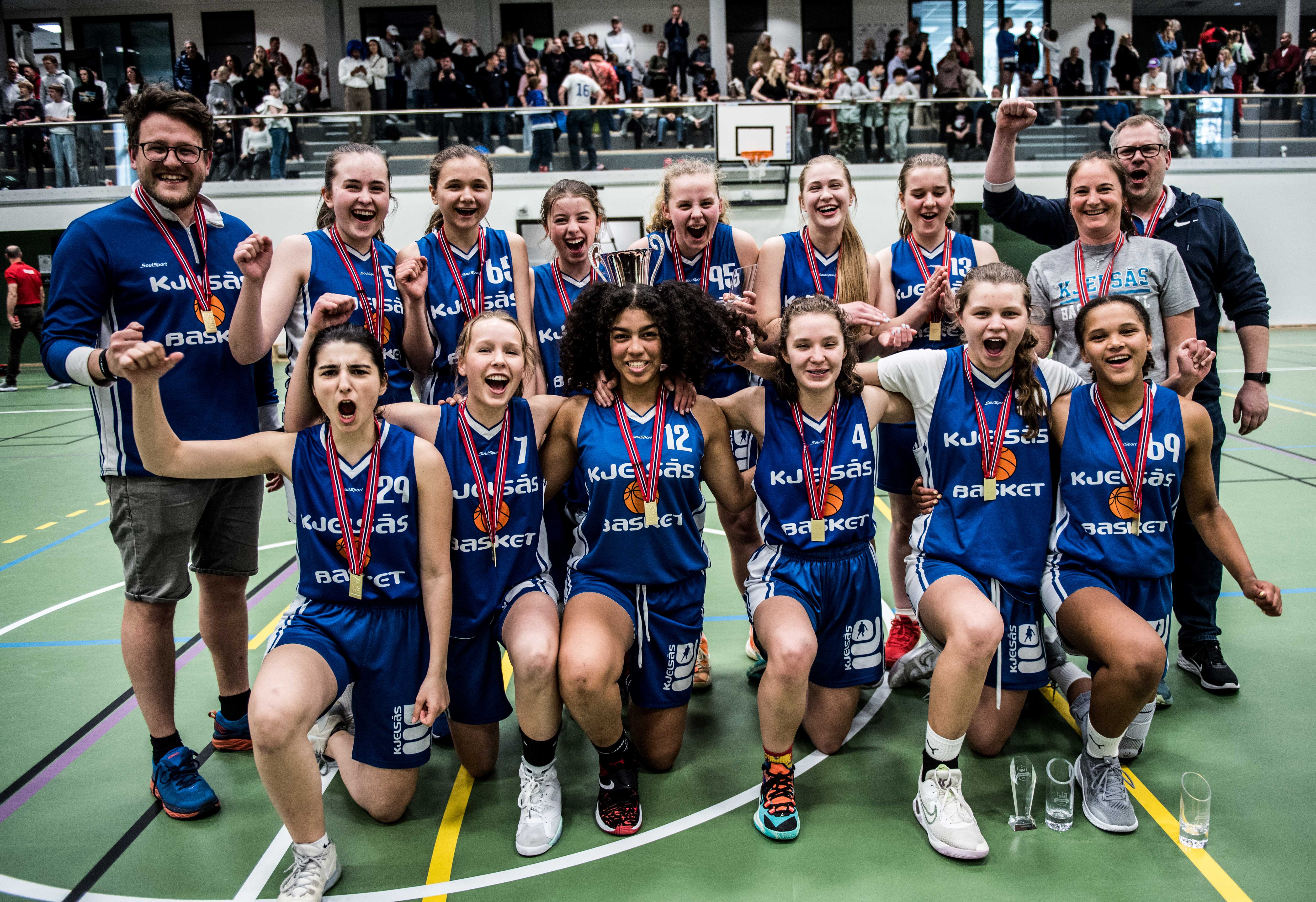 Kjelsås jubler for NM-gull i U16 etter finaleseier 84-82 over Ulriken Eagles. Bak fra venstre Jørn Nordal, Ella Julsgaard, Kari Lamvik Horn, Inga Hesthammer, Celine Mannsåker, Rakel Sif Omarsdottir, Hedda Berdahl Løken, Ingvild Johanne Rytter og Omar Örn Sigmarsson. Foran fra venstre Sofija Jozin, Johanna Kolseth Kiland, Andrea Nadine Fergem Faal, Maria Wiktoria Bogacz, Ida Johansen og Nora Werenskiold Proctor.
FOTO: ERIK BERGLUND 