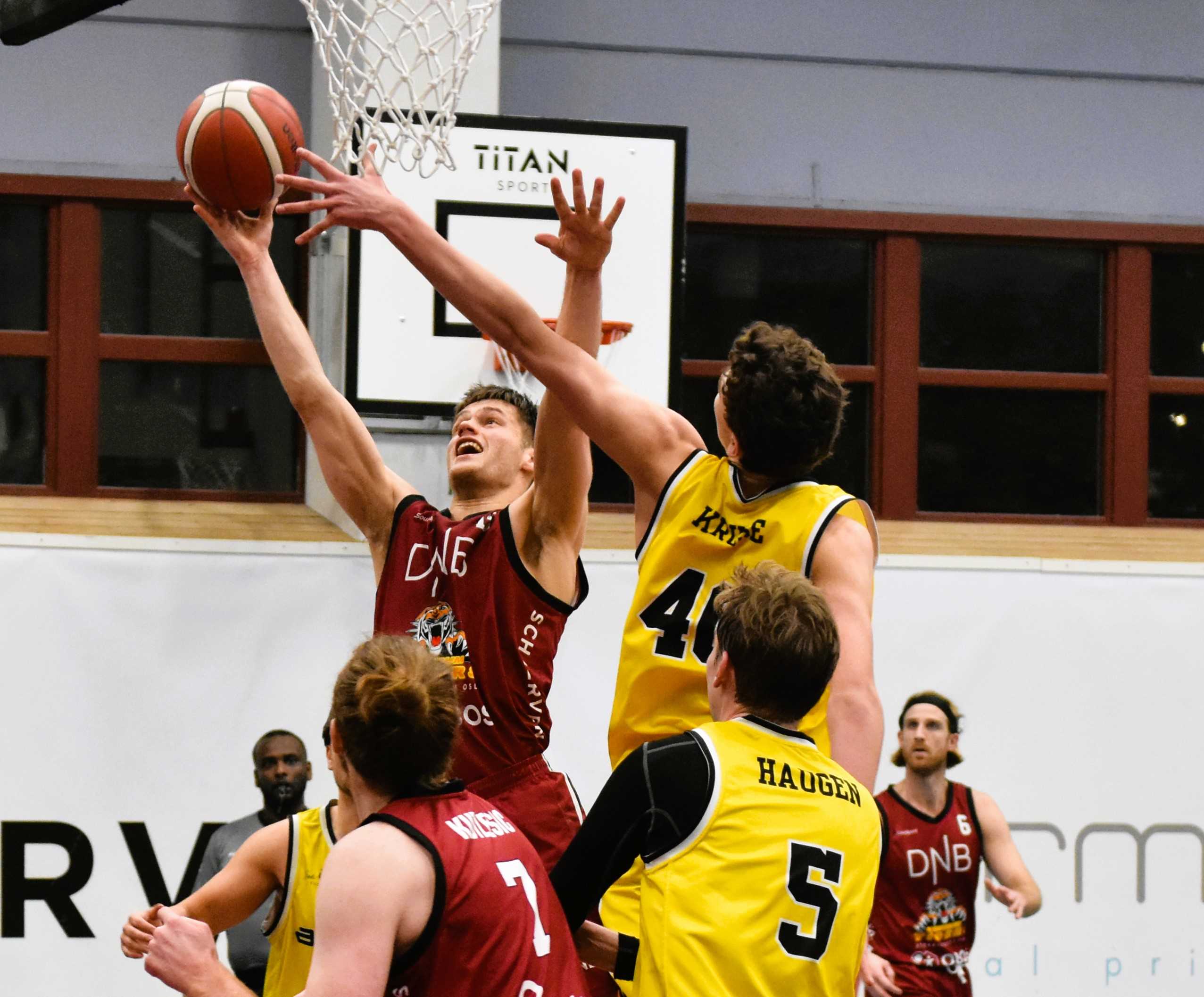 Johan Flaa styrte Centrums opphenting, scoret 11 av 24 poeng i tredjeperioden og endte med 25 poeng, 5 assists, 5 returer og 3 steals da hjemmelaget vant 87-83. Her unngår han William Kruses blokkforsøk og får avsluttet på kurven. Med ryggen til er Petar Kutlesic og Gaute Haugen, bak til høyre er Stian Emil Berg og til venstre dommer Bereket Leta.
FOTO: MARIANNE MAJA STENERUD 