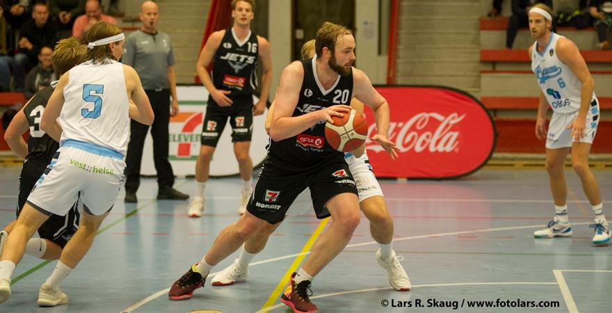 ​Brage Sørensen hadde en god kamp mot Bærum med 11 poeng, 4 returer og 4 assists for Nidaros Jets - og 3-poengeren til 82-79 et minutt før slutt. Her driver Nidaros-forwarden mot Alex Dakin (skjult bak), mens Gaute Haugen (nr 5) dekker Simon Midtvedts løp. I bakgrunnen ser vi Mats Selboe og Stian Emil Berg.