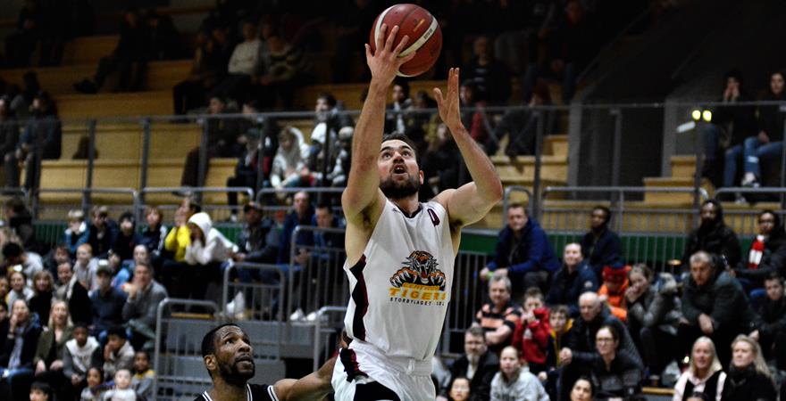 ​Magnus Midtvedt ble toppscorer med 29 poeng og matchvinner for Centrum Tigers med to 3-poengere og to straffekast i siste spilleminutt. Her scorer Centrum-kapteinen på en layup, med Ammeruds Orji Okoroafor i hælene.