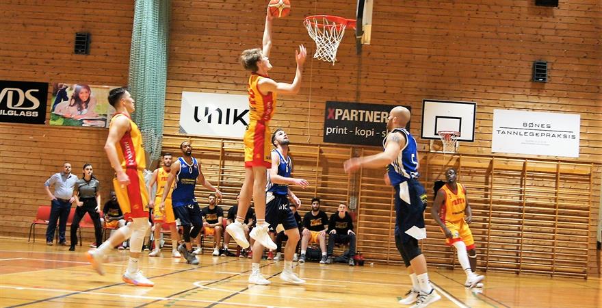 ​19-årige Marcus Larsson gjorde en sterk kamp for Frøya, med 16 poeng - inkludert to dunker tidlig i fjerde periode. Her legger den 2,06 m lange forwarden den ene, med Evan Harris (til venstre), Brede Raa Ellingsen og Karl Otabor som hjelpeløse tilskuere. De øvrige Frøya-spillerne i bildet er fra venstre Arne Ingebrigtsen, Ognjen Nisavic (bak Harris) og Junior Lomomba.